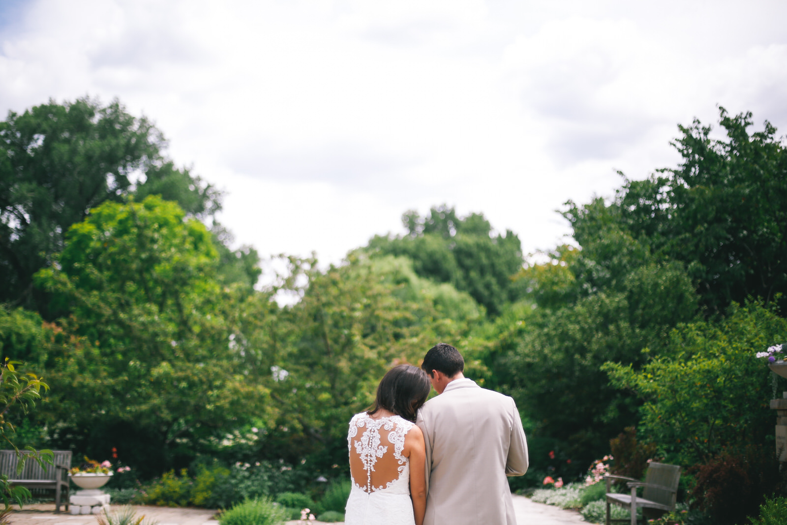 couple walks on their wedding day at olbrich botanical gardens in madison wisconsin
