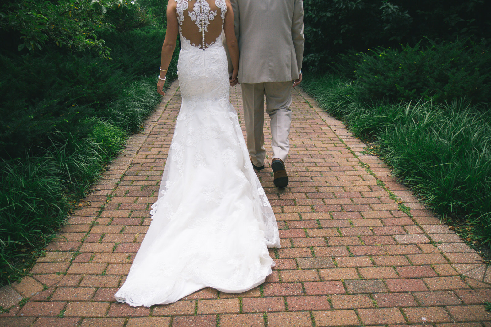 couple walks on their wedding day at olbrich botanical gardens in madison wisconsin