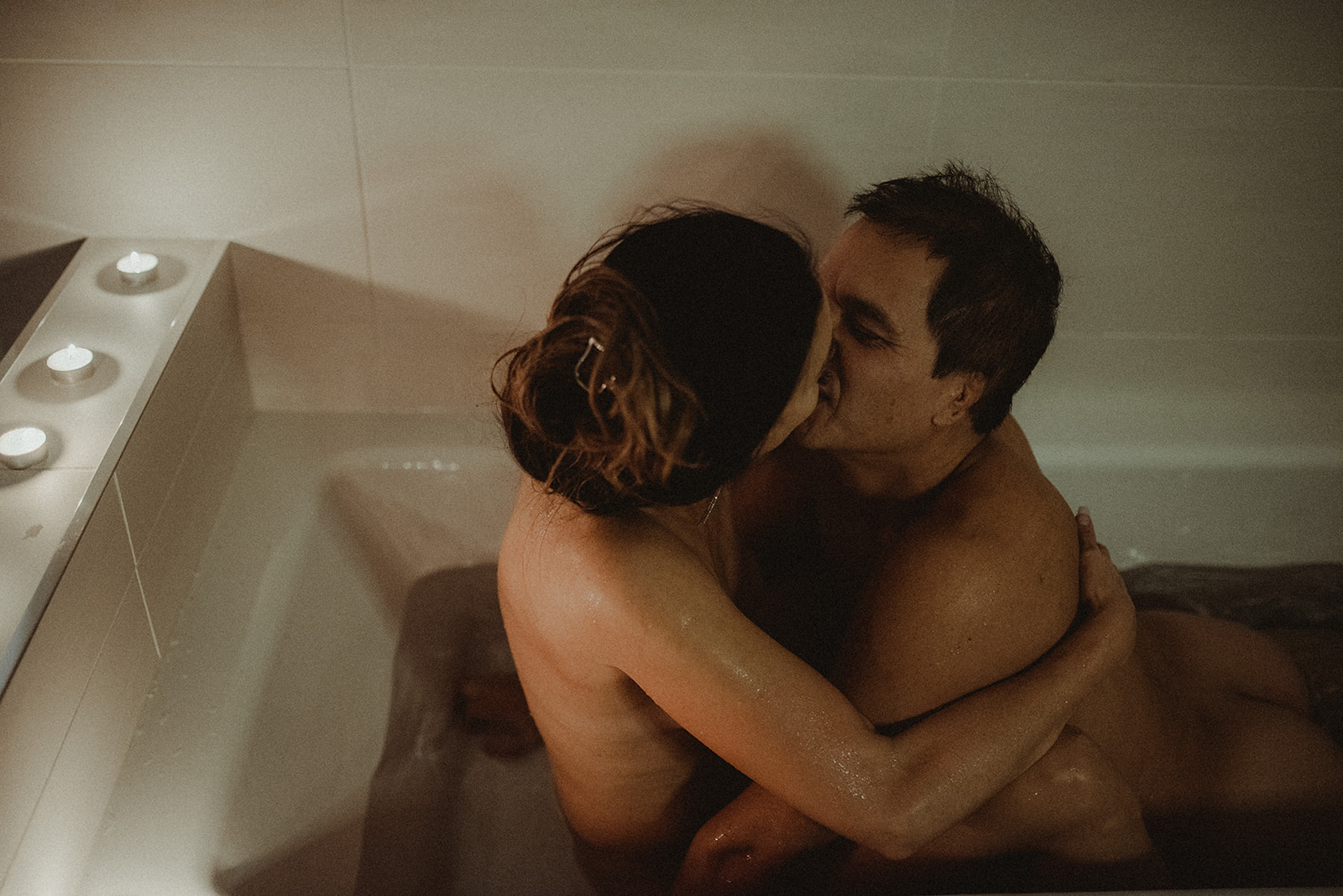 couple shares an intimate moment in the tub during their boudoir photoshoot