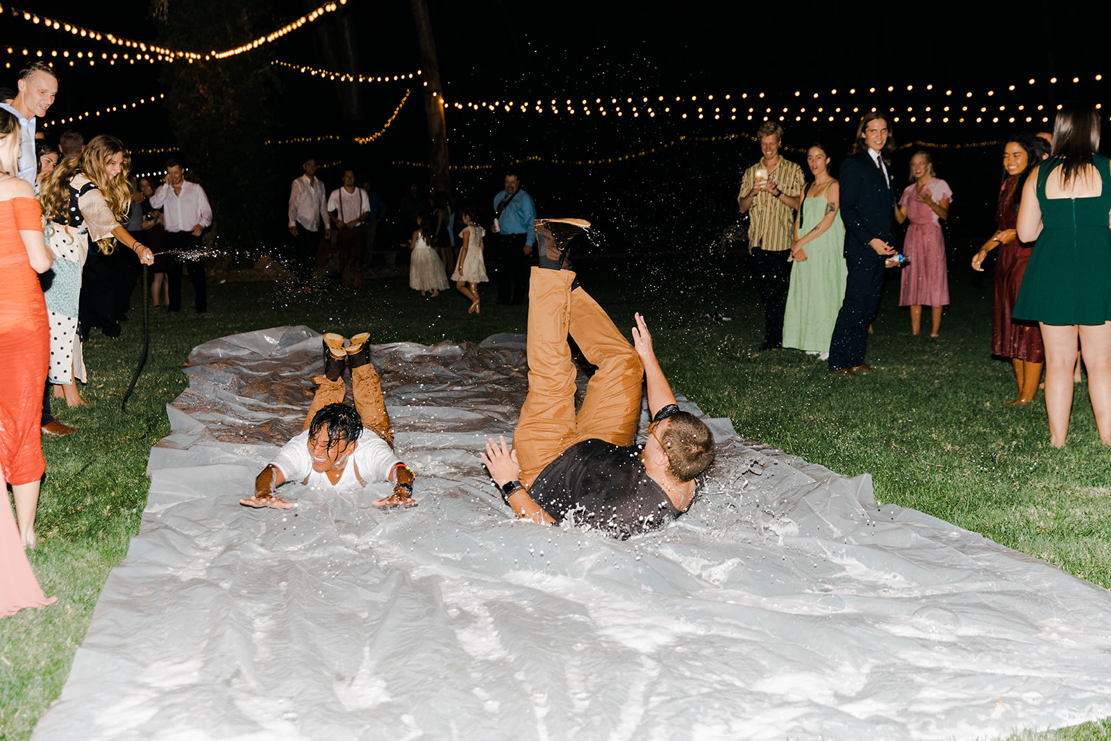 boho- chic couple does a slip 'n slide wedding exit followed by the bridal party and guests