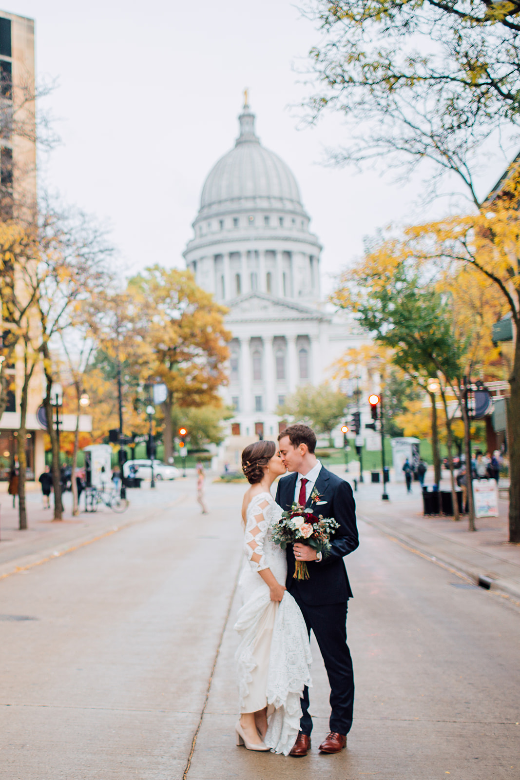 couple embraces on state street on their wedding day in madison wisconsin