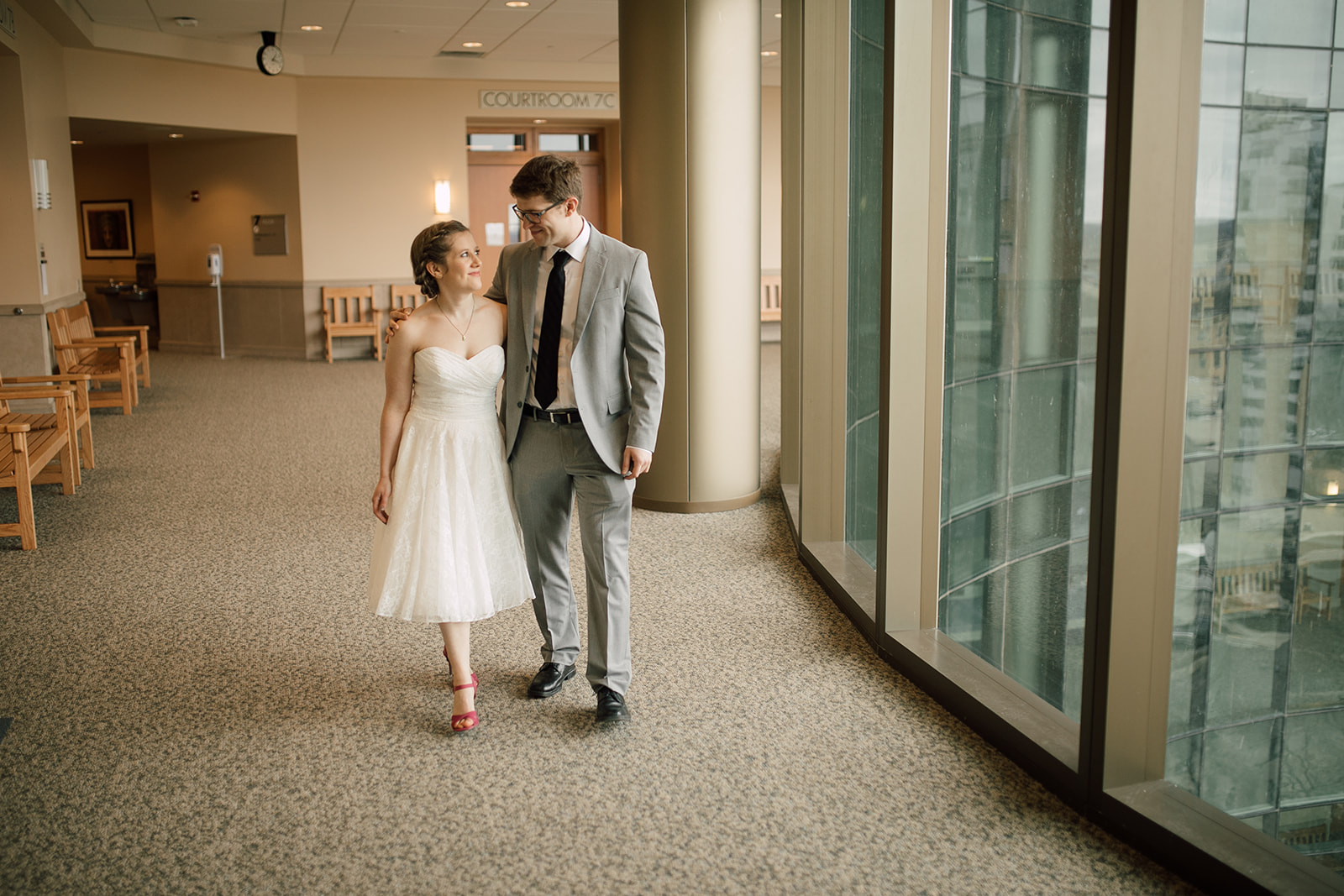 couple walks in hallway before their intimate courthouse elopement in madison wisconsin