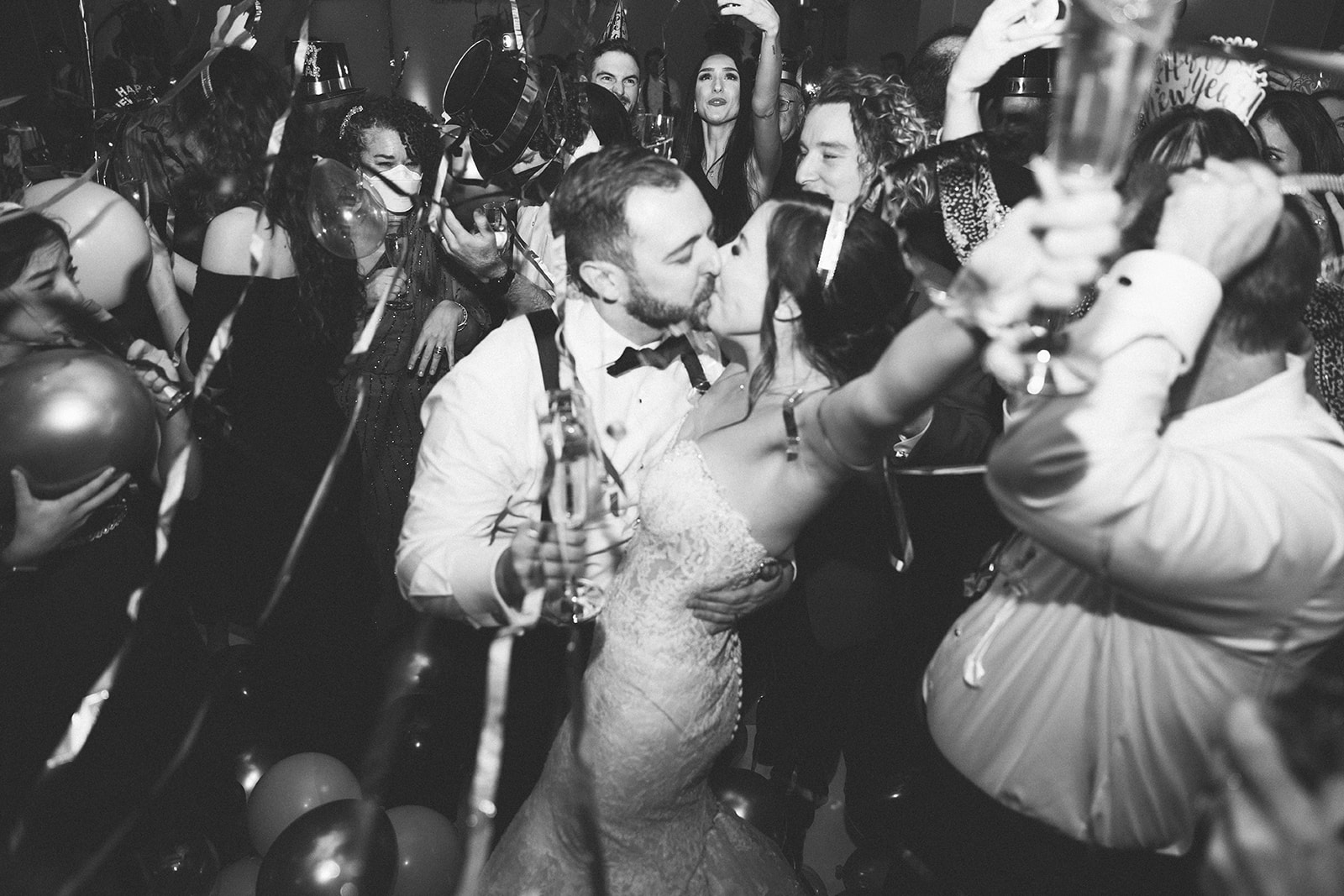 Couple kisses as the balloons drop at midnight to celebrate New Years Eve at this winter wedding. 