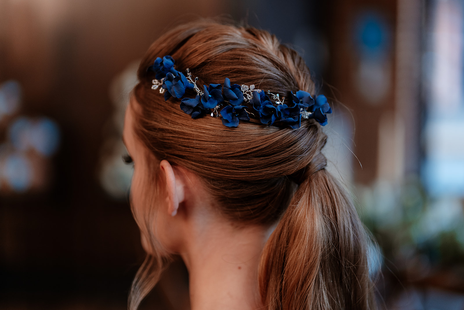 Close up of blue floral accessories in a bridal ponytail. 