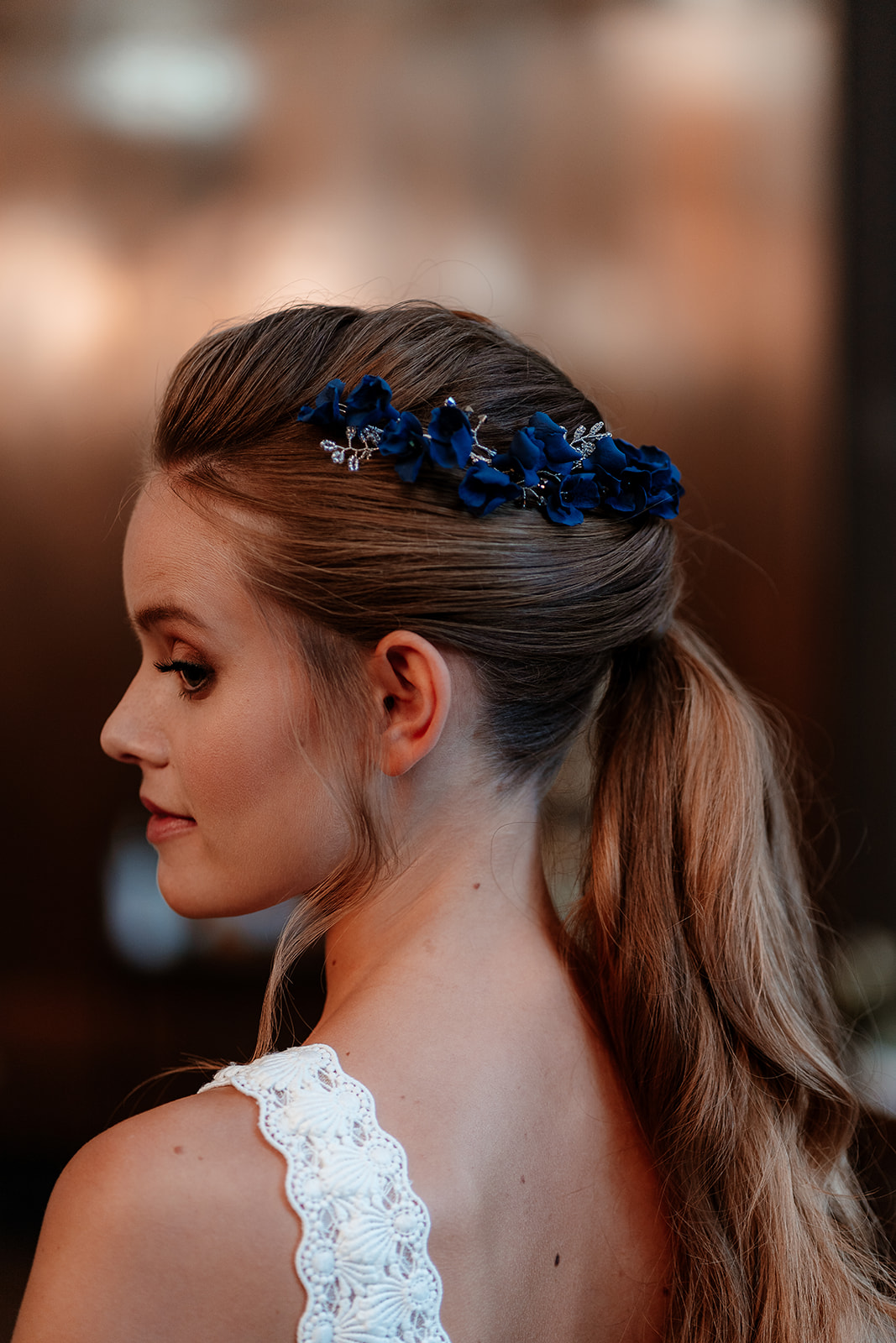 Close up of blue floral accessories in a bridal ponytail. 