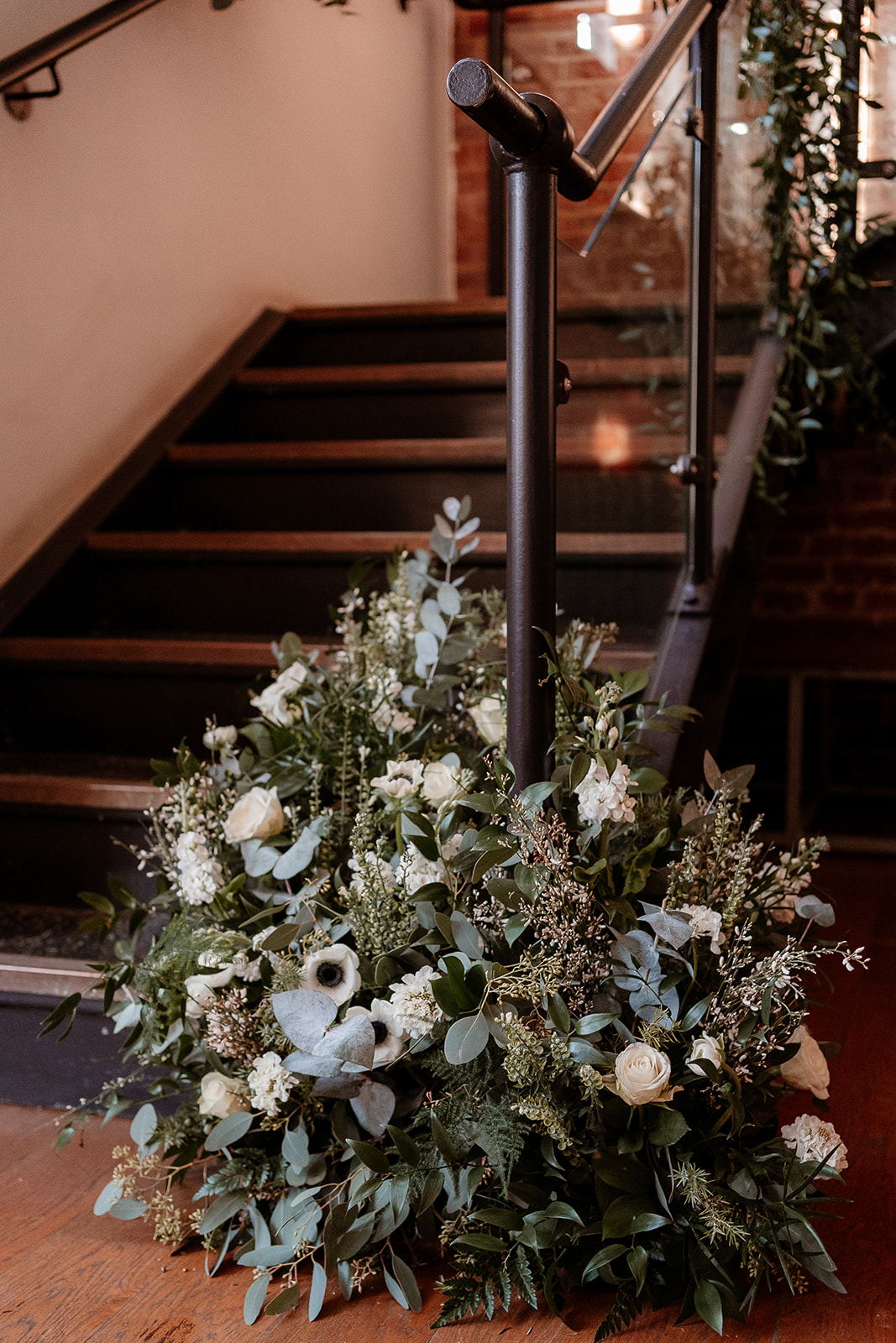 A cascade of white flowers and green foliage at the foot of a staircase bannister at the Bombay Sapphire Distillery. 
