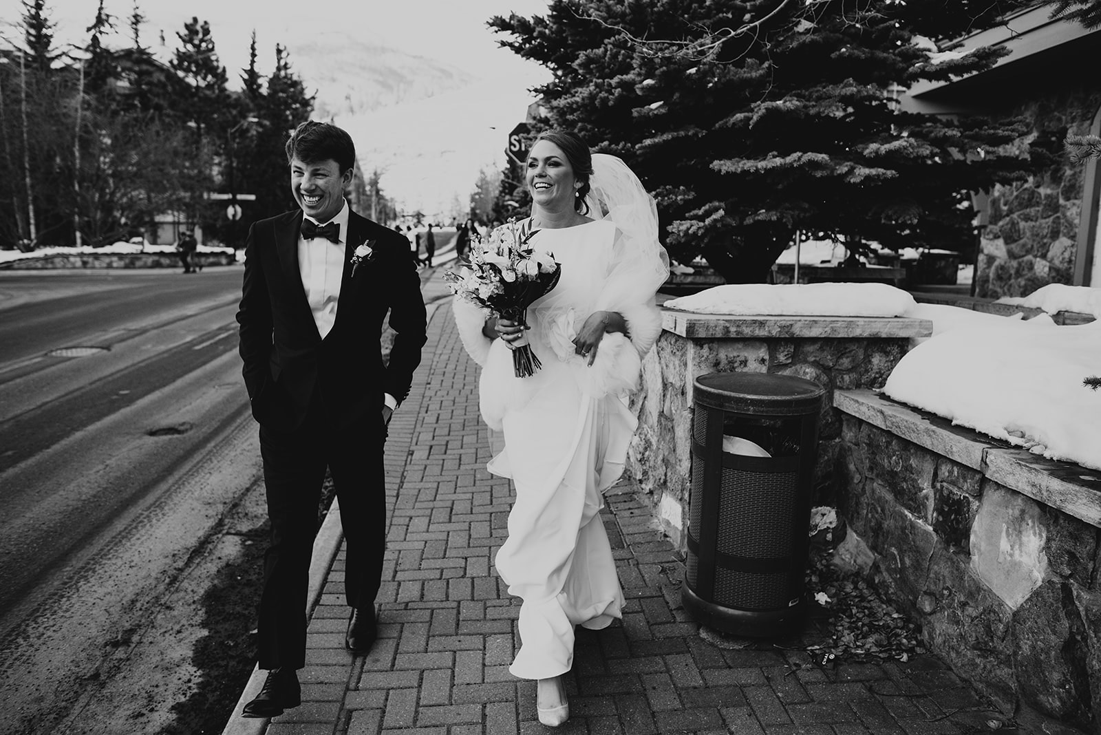 A couple that got married in Vail Colorado walks through vail village in their wedding attire