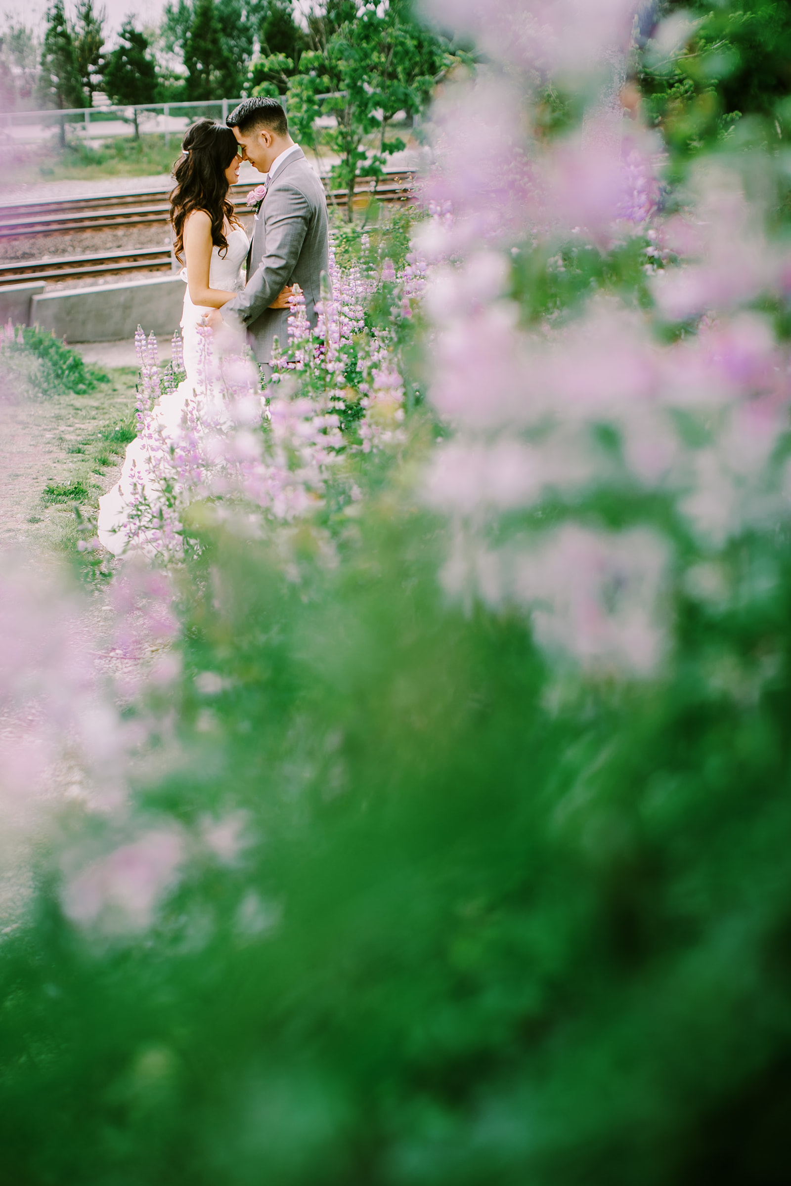 Bride and groom wedding portraits at the Olympic Sculpture Park summer with larkspurs growing