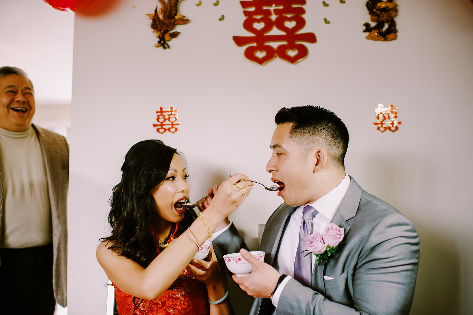 Happy couple feeding each other sweet tang yuen glutinous rice balls for luck Chinese wedding tea ceremony