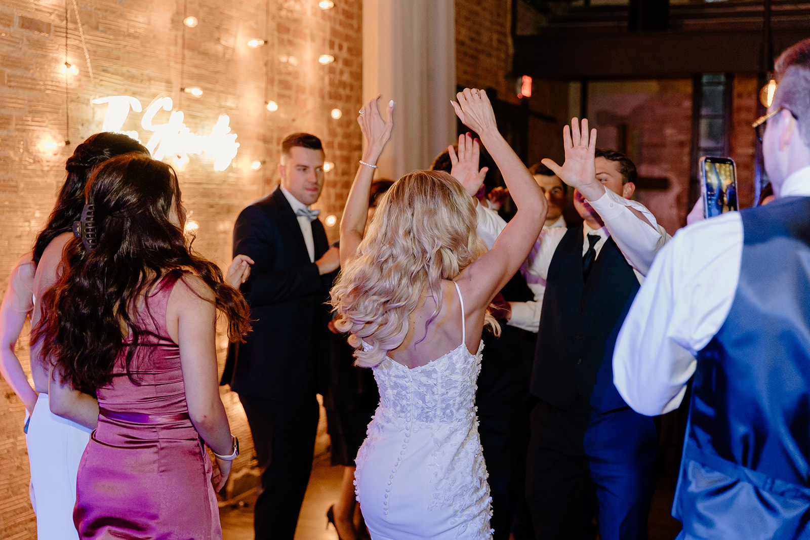 Bride and groom party on the dance floor with all of their wedding guests.