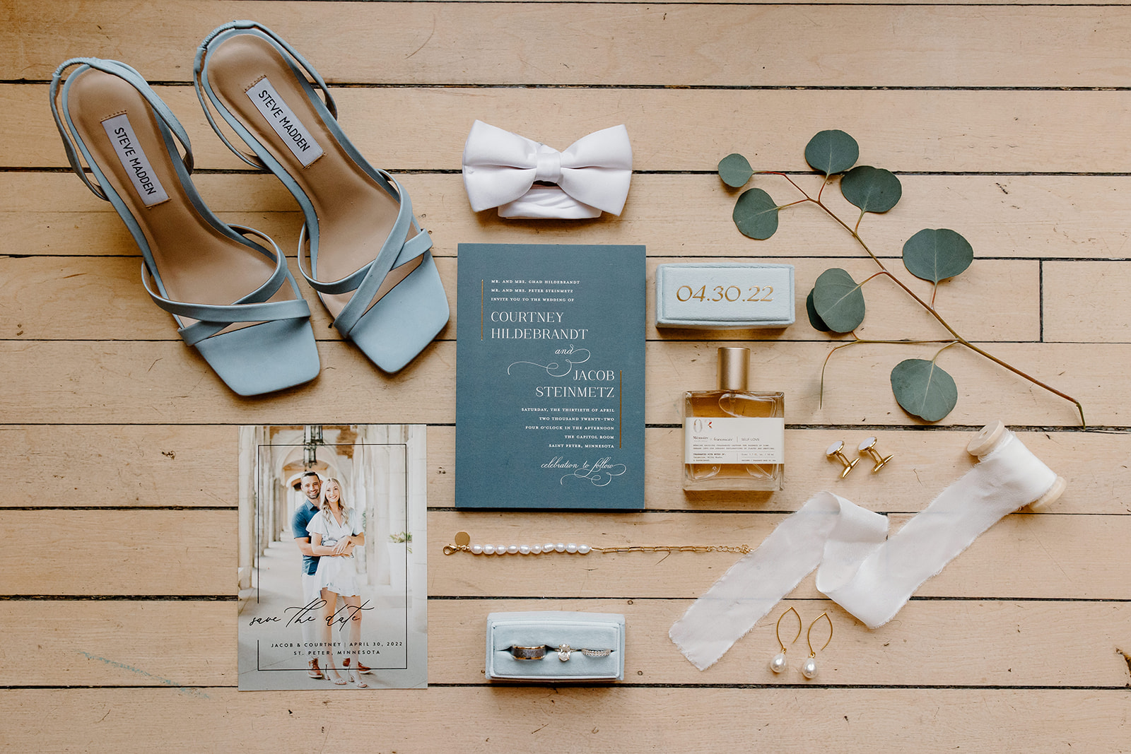 A flat lay of the bride's wedding day details laid out on the floor. 