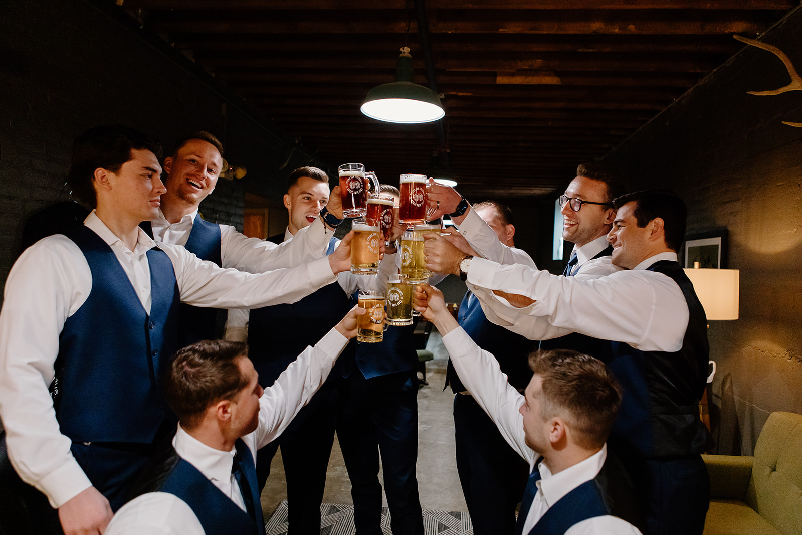 Groom and his groomsmen cheers their matching steins on his wedding day.