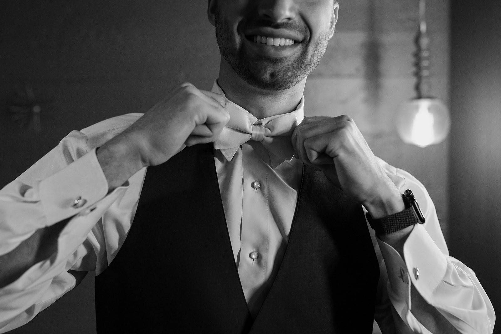 Groom straightens his tie right into the camera.