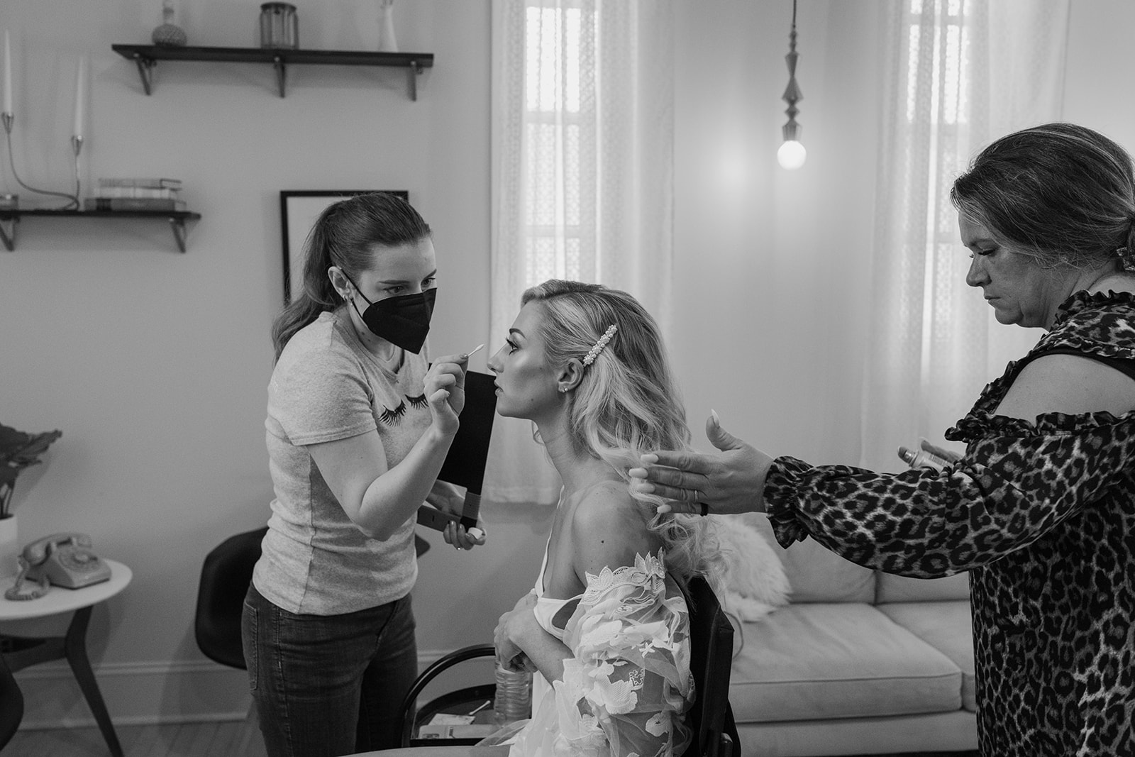 The bride getting pampered by both her hair and makeup artists.