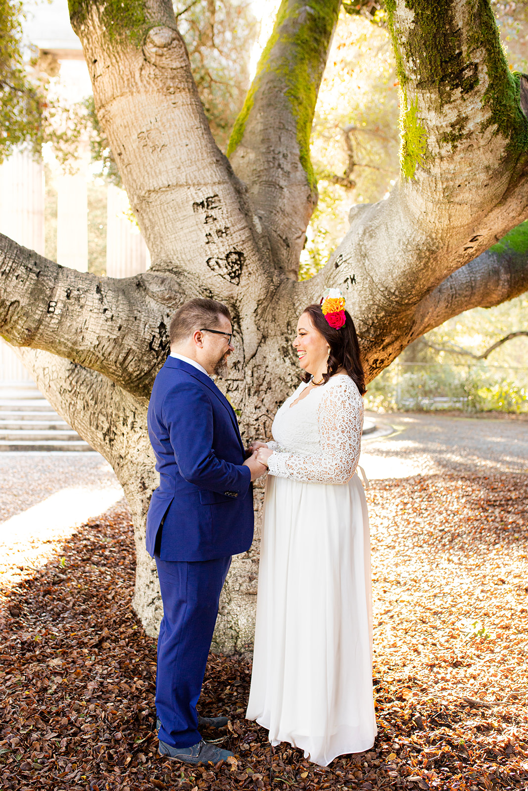 bride and groom exchange vows in front of tree