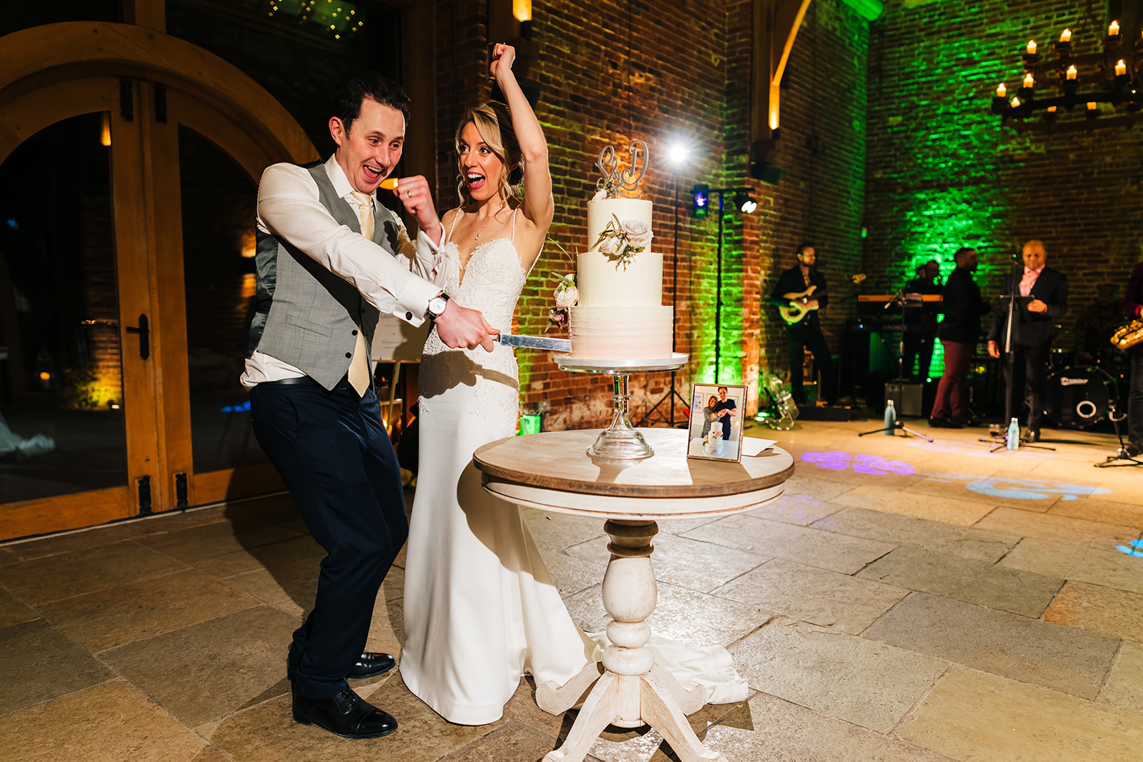 Hazel Gap Wedding Photography - the bride and groom, cutting the cake in the main barn
