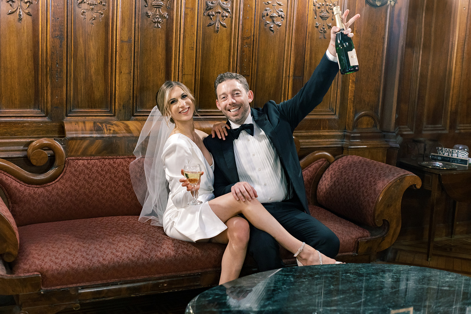 Bride and Groom pose with champagne glasses in hand. 