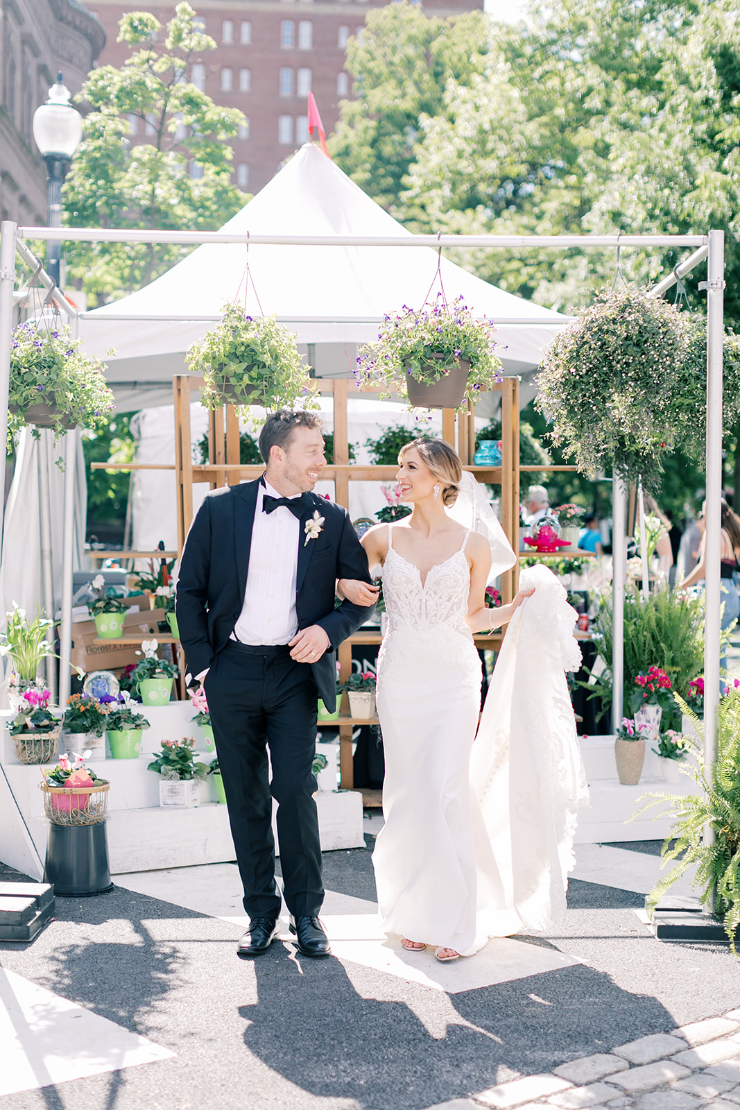 Bride and Groom pose in front of a flower tent. 