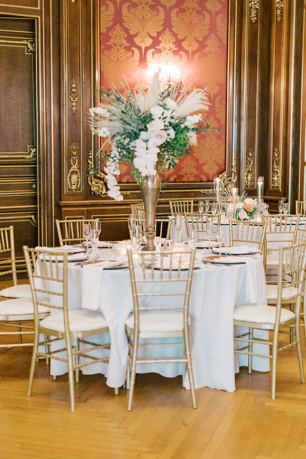 Table scape with white linen and gold chairs. 