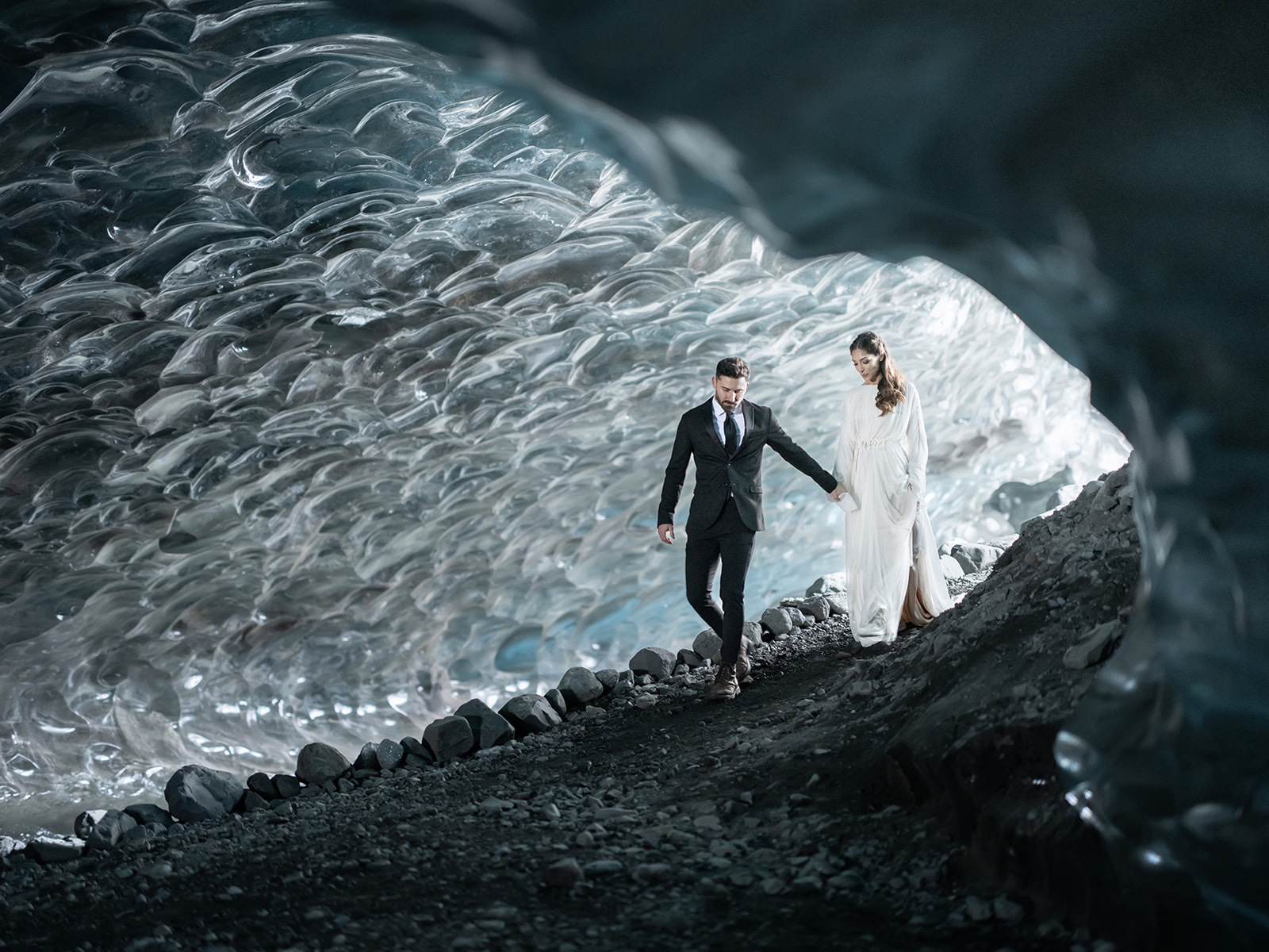 Bride and Groom holding hands as they enter an Ice Cave in Iceland during their elopement.