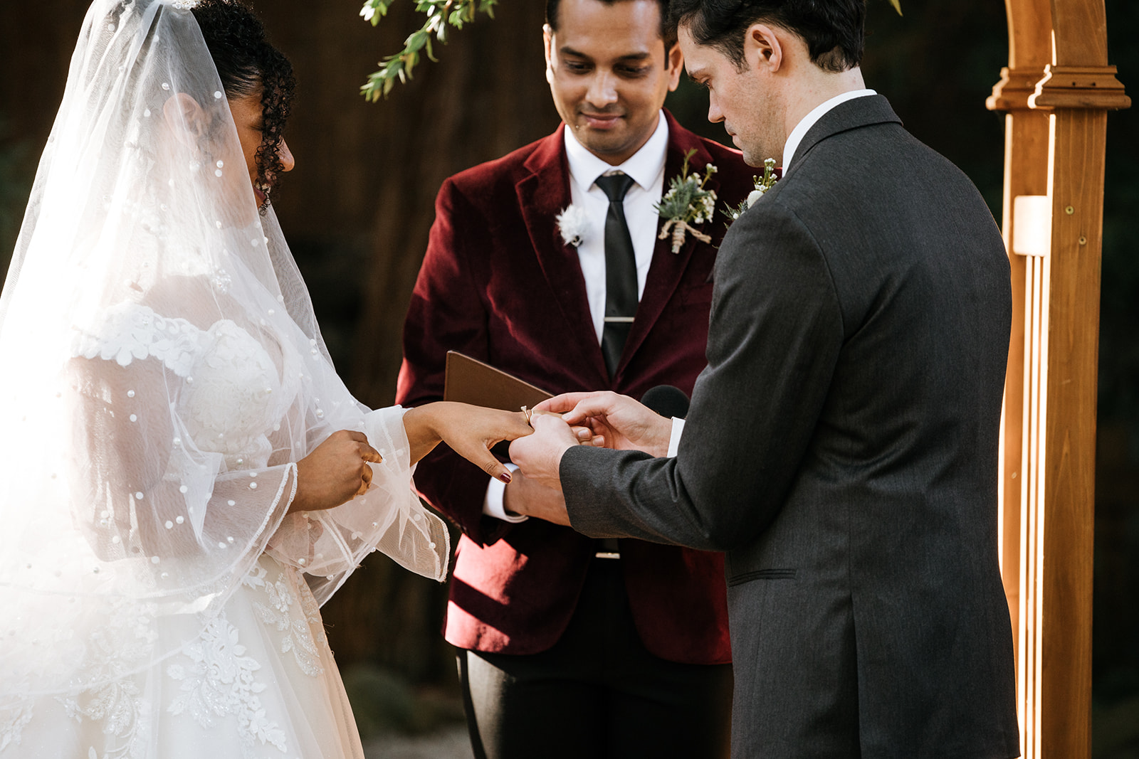 Bride and groom exchange rings during ceremony 