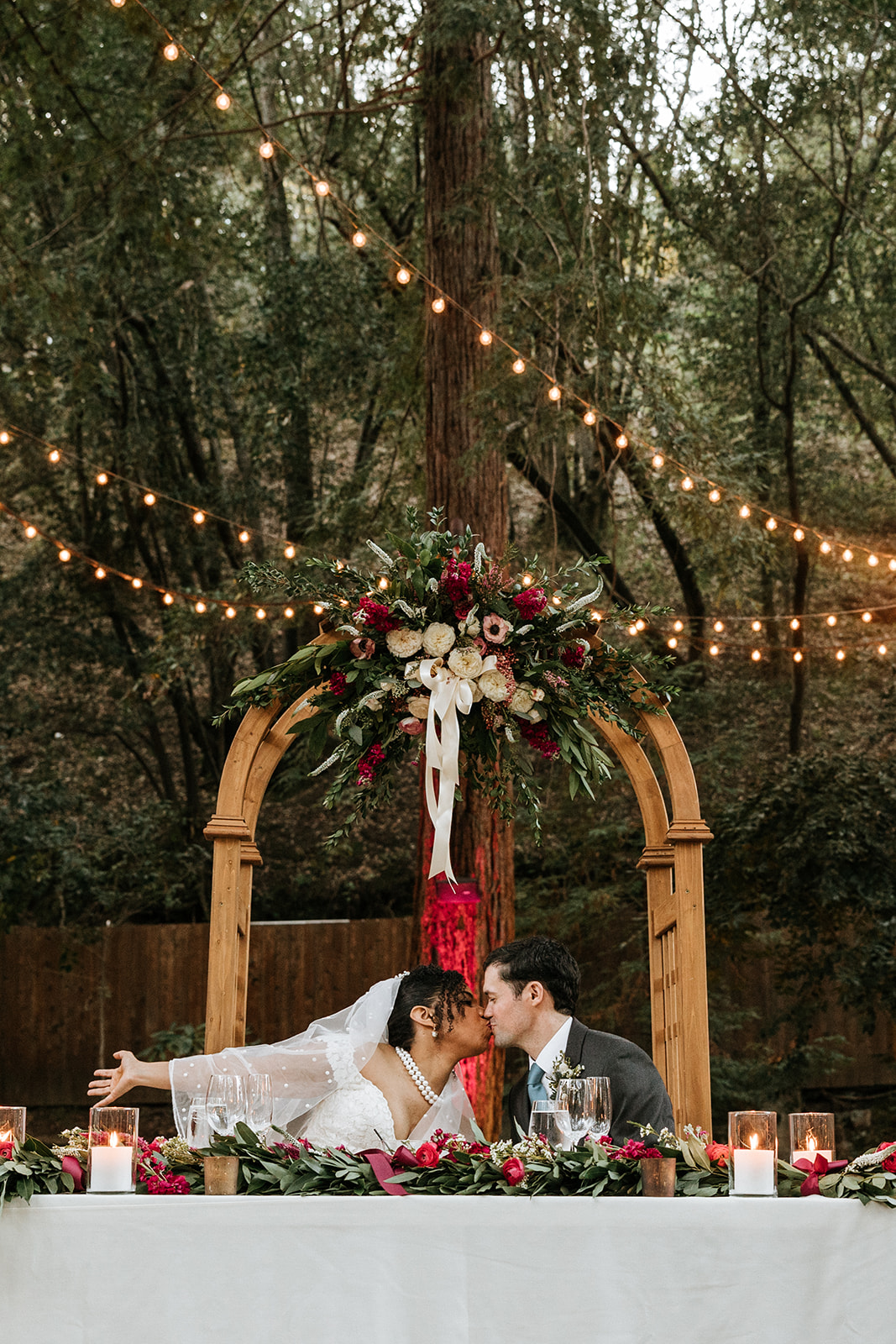 Bride and Groom kissing underneath the Redwoods during reception
