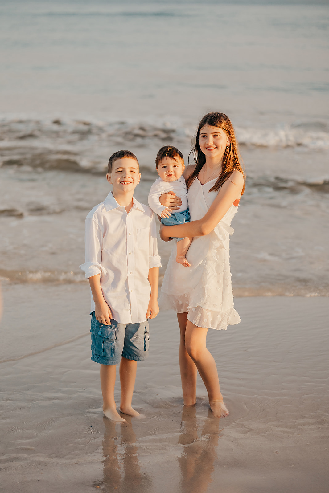 Beach Family Photoshoot in Orange Beach - Family group photo with water and rocks in the background