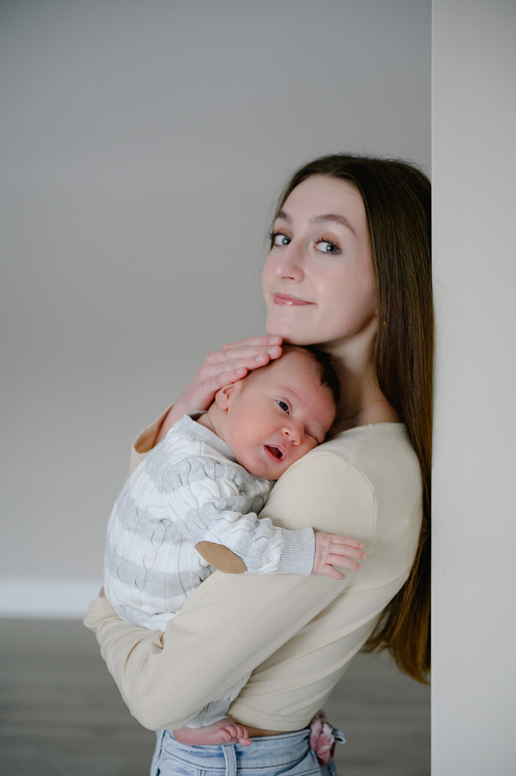 Teenage sister holding her newborn baby 