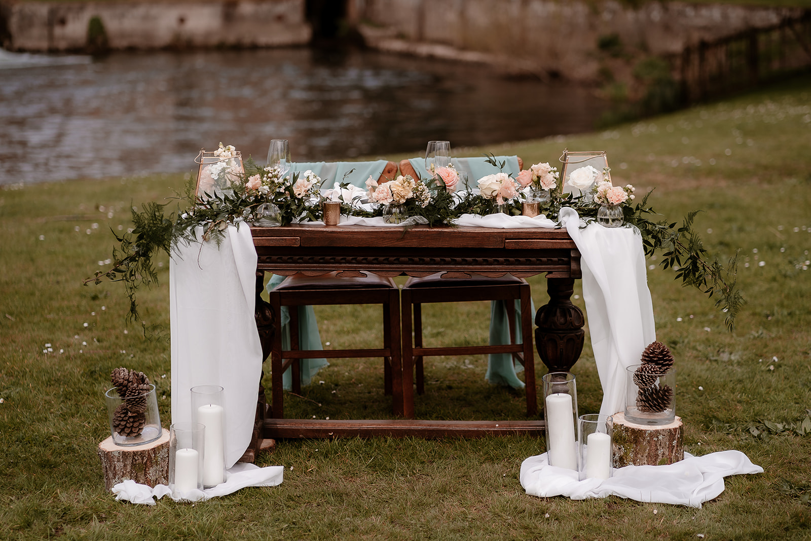 sweetheart table set up on the grounds of Mapledurham House wedding venue with chiffon drapes and candles in votives
