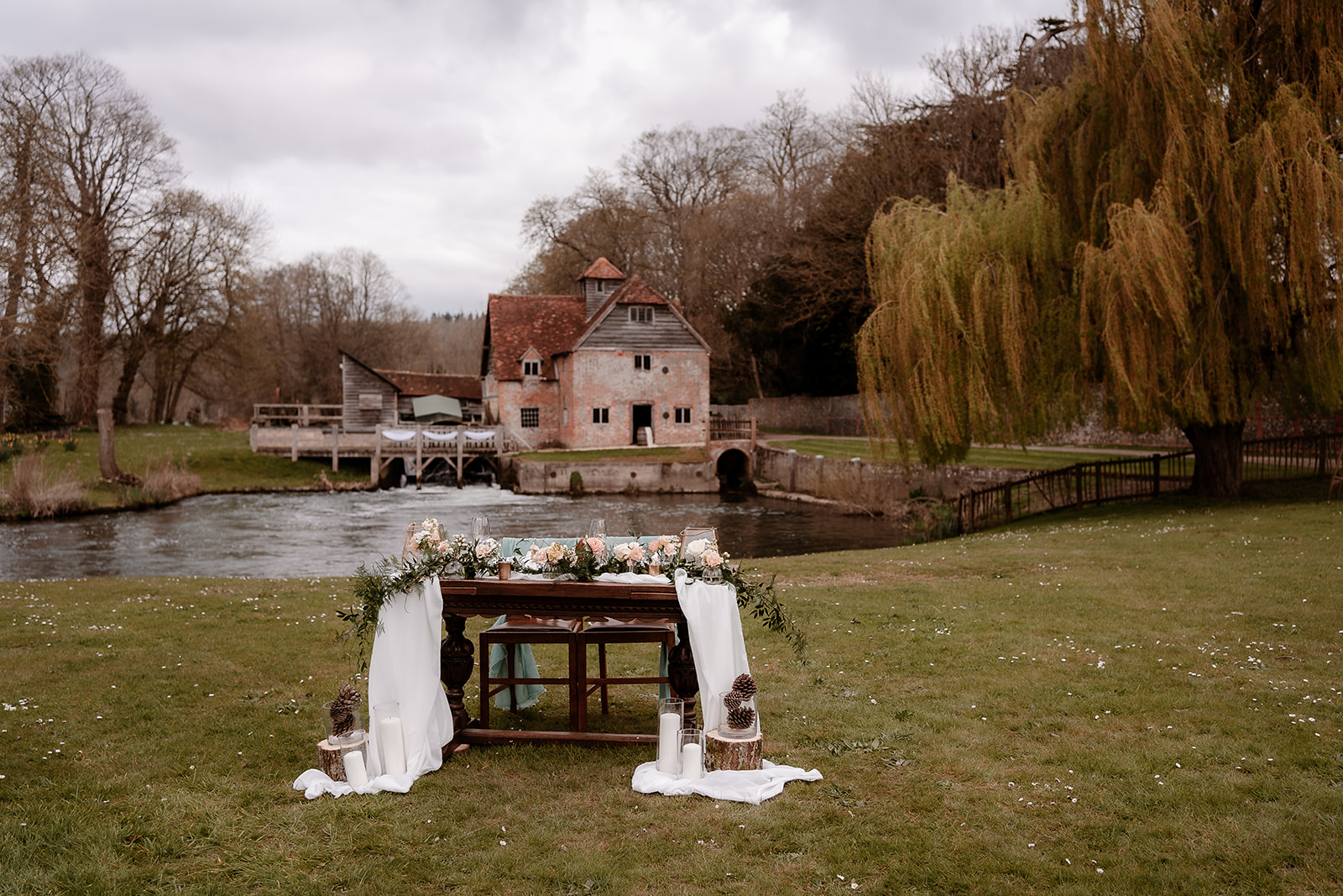 sweetheart table set up on the grounds of Mapledurham House wedding venue with views of the watermill behind
