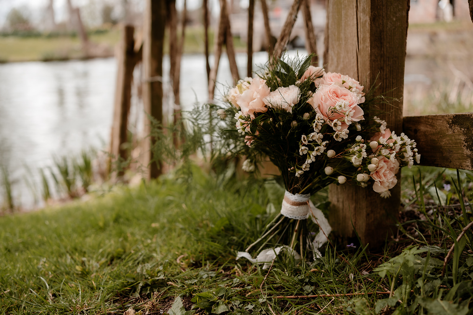 Wedding bouquet posy with peach flowers on the banks of the river at Mapledurham House wedding venue