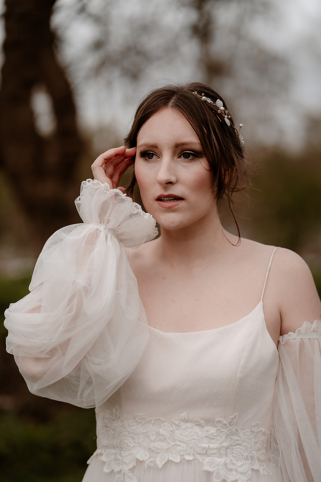 portrait of a bride wearing a tulle wedding dress with sheer sleeves and soft updo at Mapledurham House wedding venue