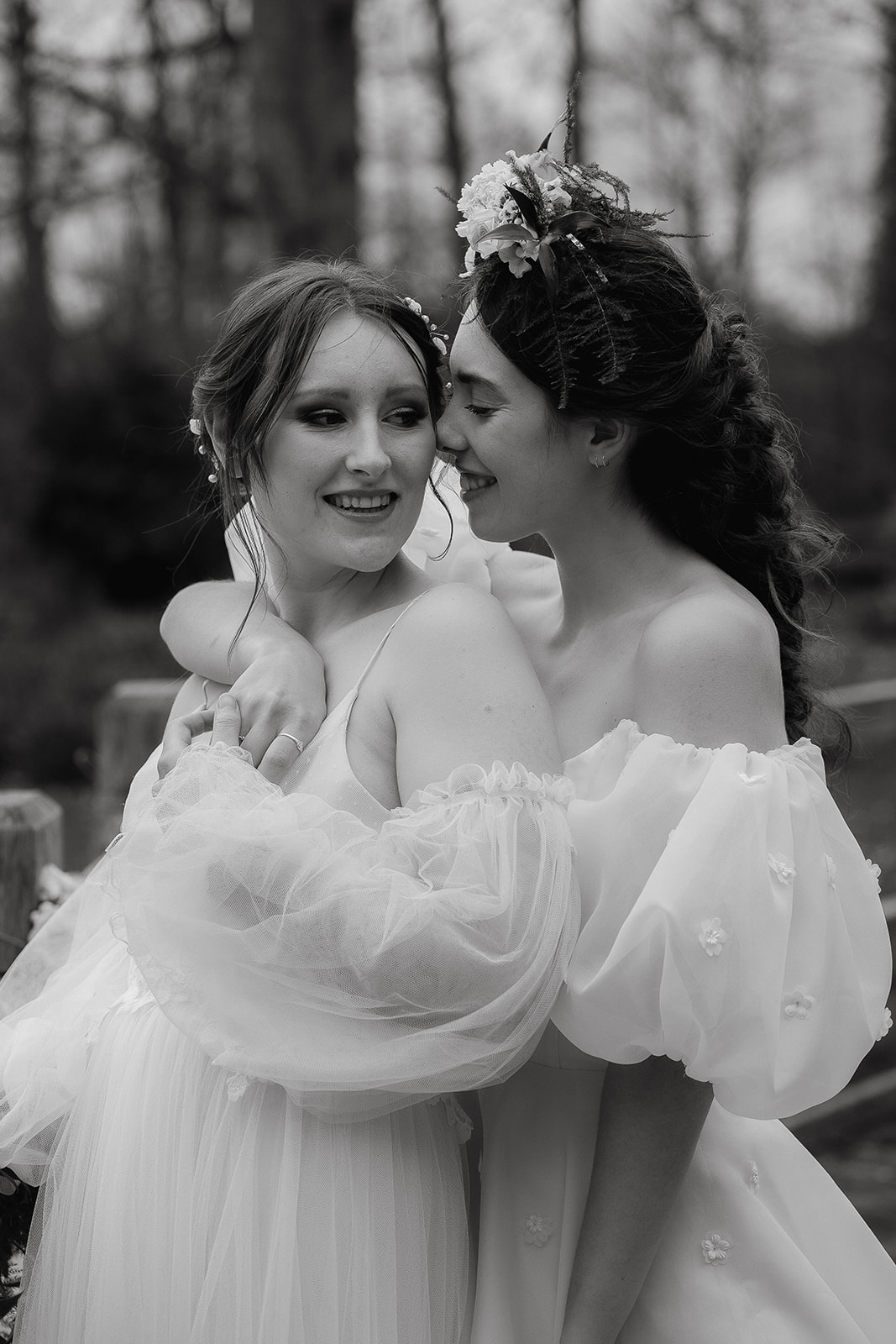 two brides snuggle together on the grounds of Mapledurham House wedding venue in the spring sunshine