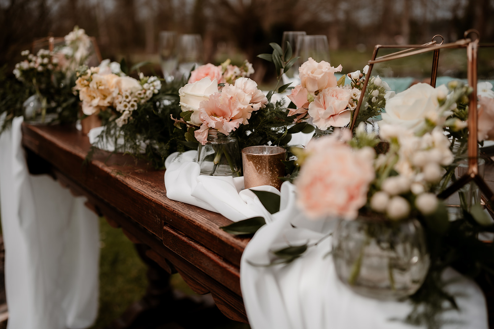 Close up of the peachy toned flowers on the sweetheart table set up on the grounds of Mapledurham House wedding venue