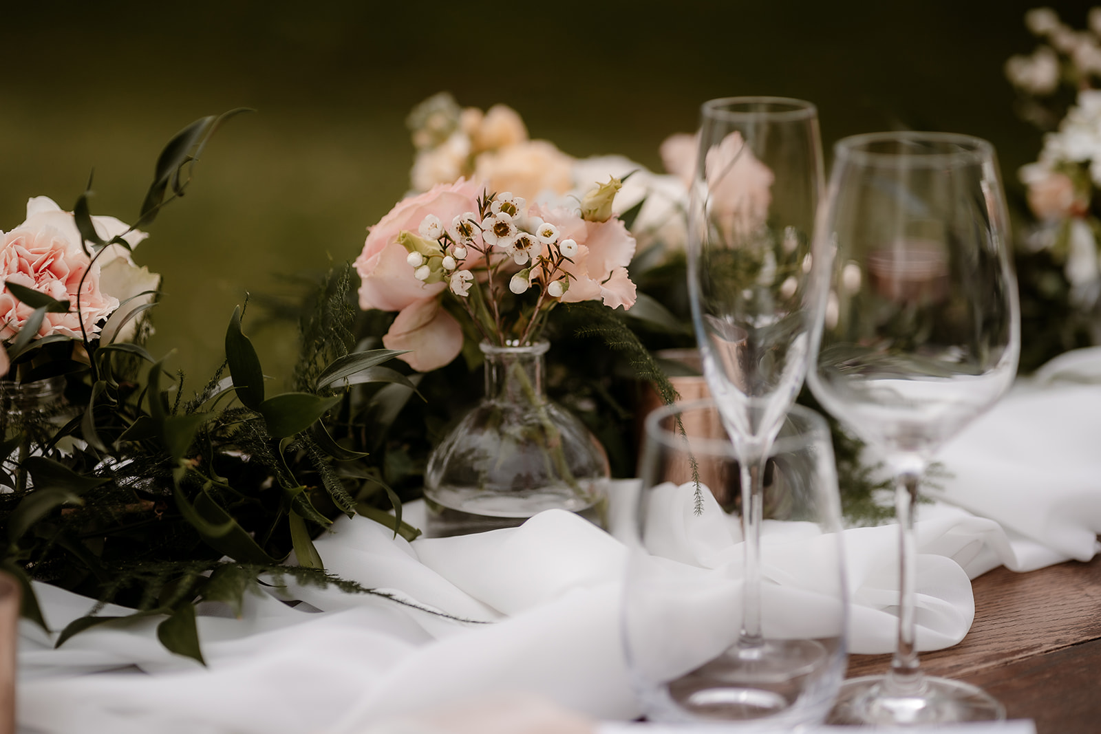 Close up of the peachy toned flowers on the sweetheart table set up on the grounds of Mapledurham House wedding venue