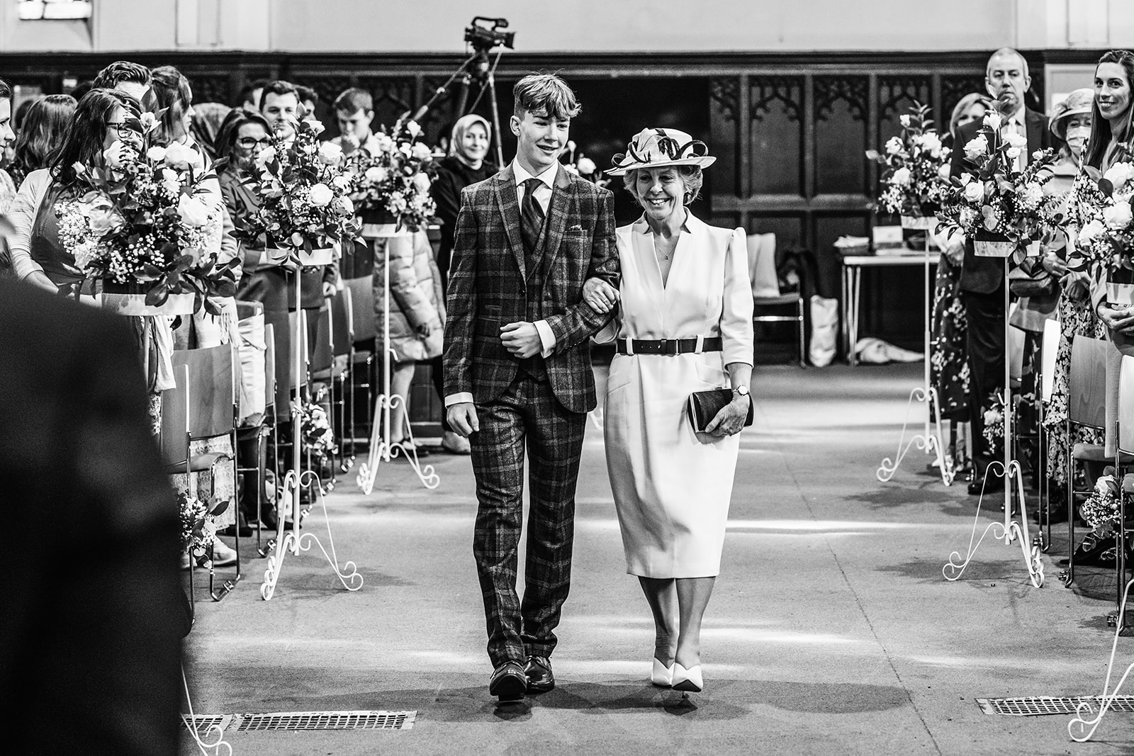 A mother and son walk down the aisle