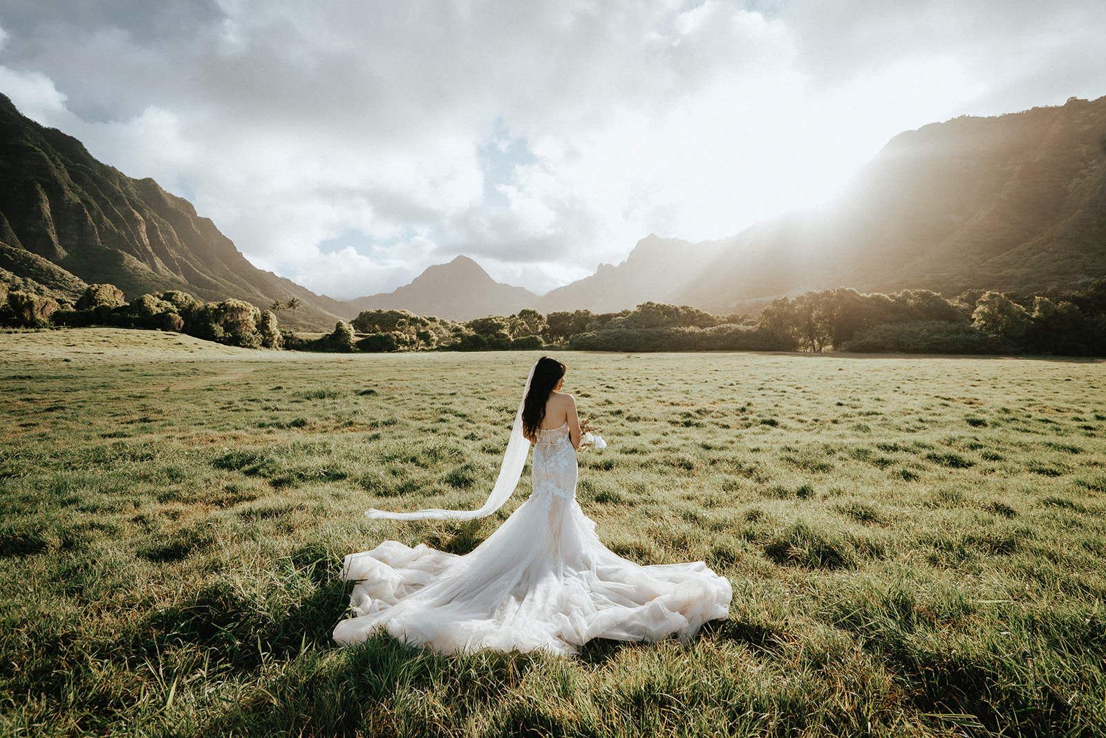 A Bride on a sunny field after the wedding in Kualoa Ranch