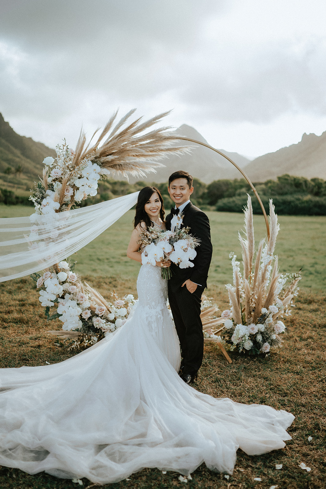A couple that just got hitched in front of their arbor in Kualoa Ranch