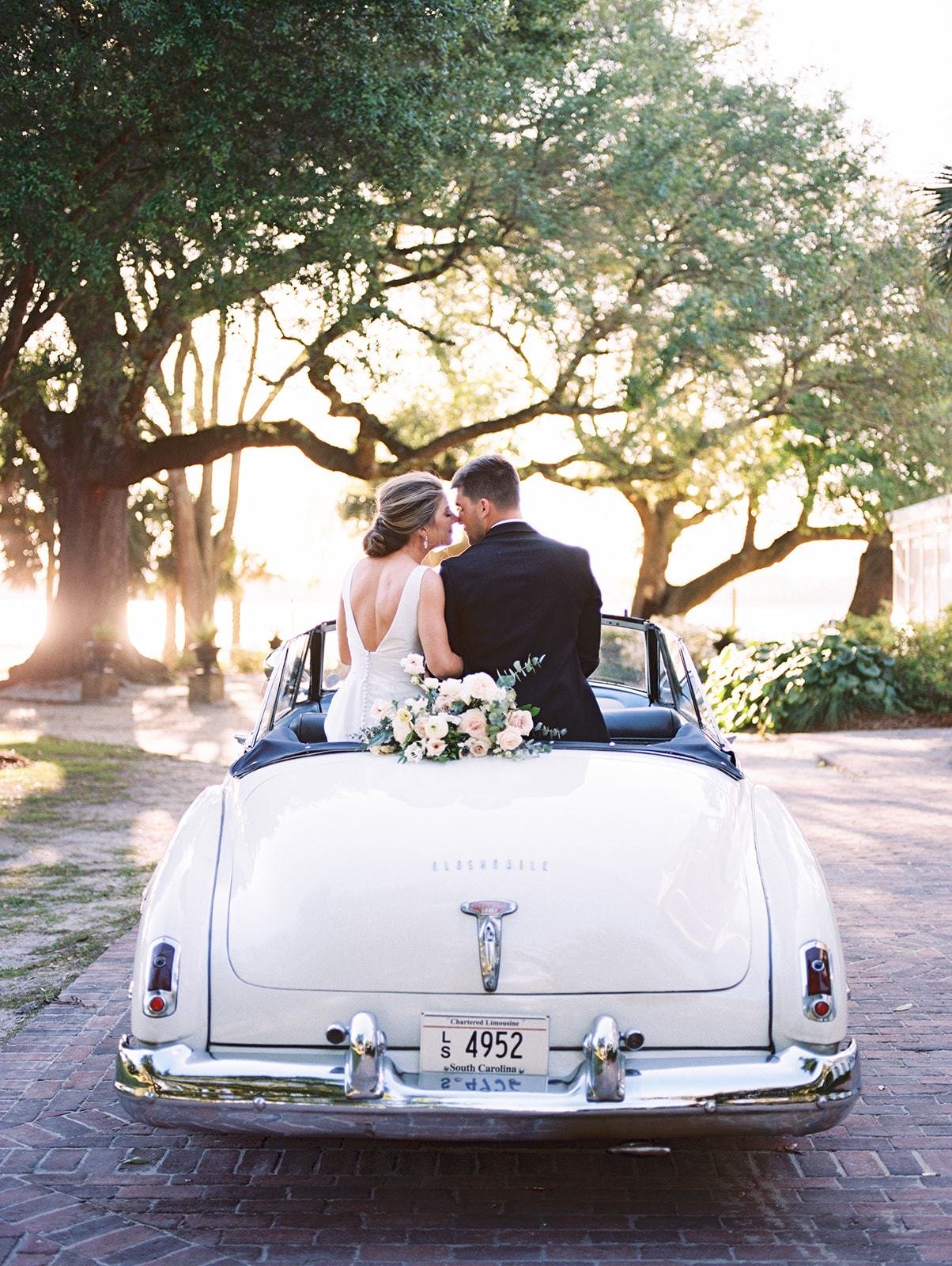 bride and groom with vintage car at lowndes grove in charleston