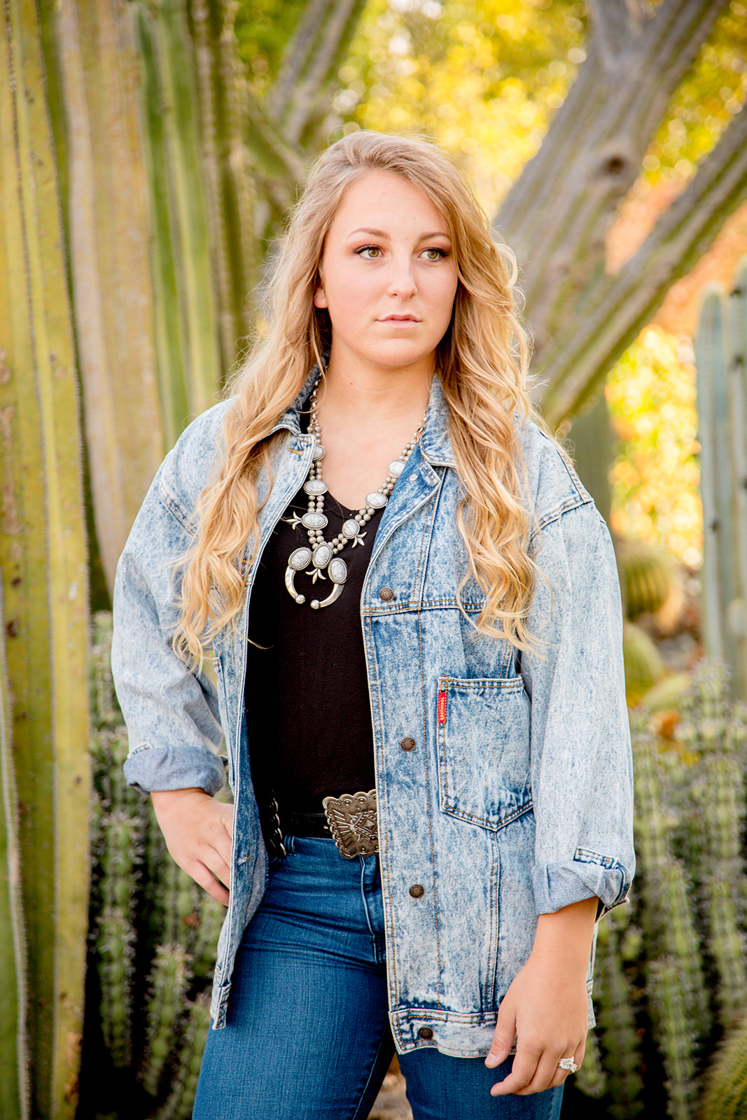 Cal Poly senior wearing jean jacket for western styled photoshoot at the Cal Poly campus