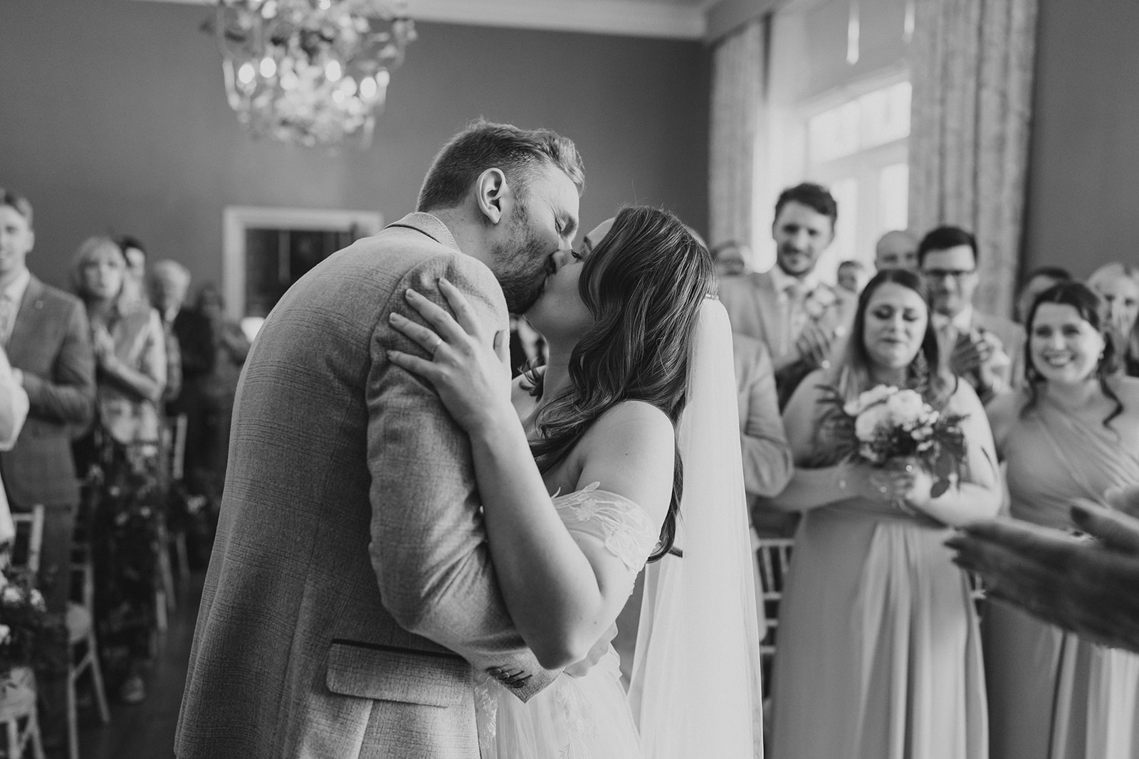 Hodsock Priory Wedding Photography - the bride and groom kissing during their wedding ceremony