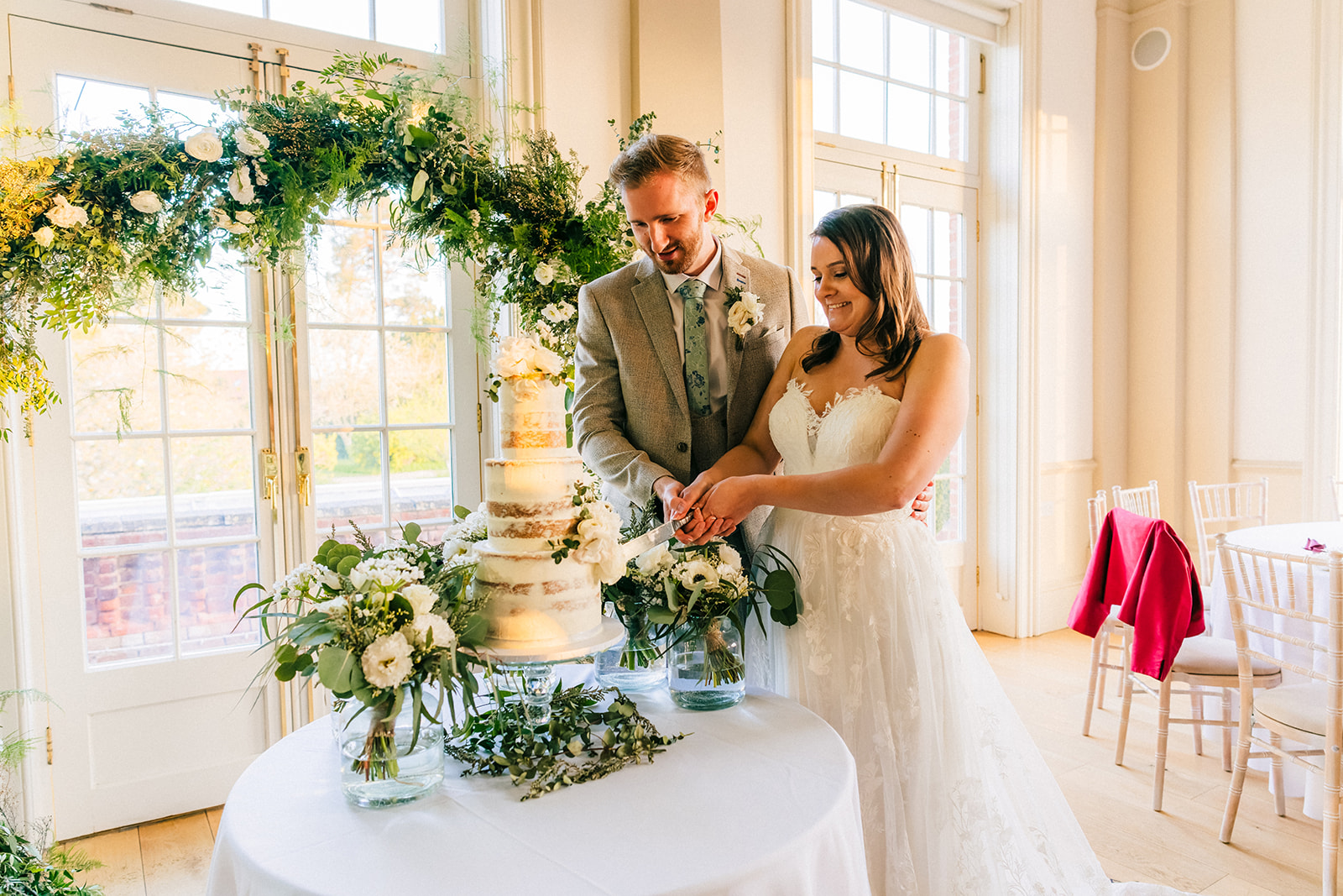 Hodsock Priory Wedding Photography - the bride and groom cutting the wedding cake