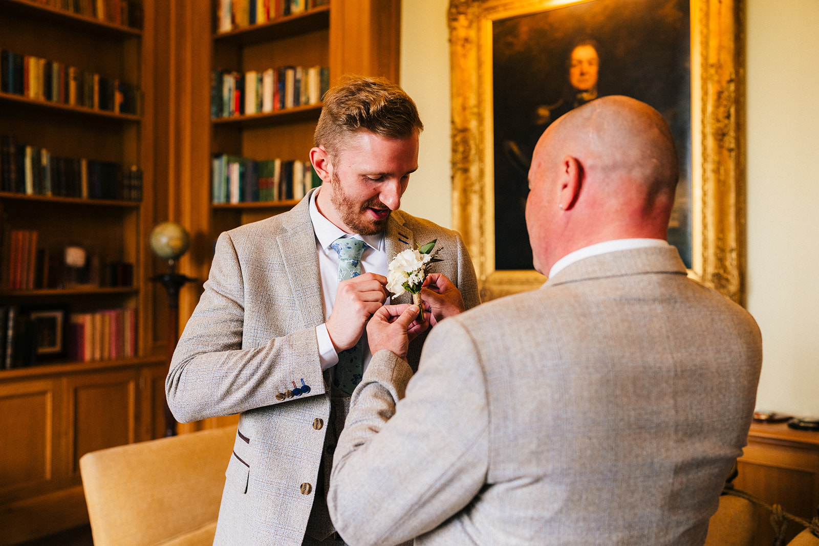 Hodsock Priory Wedding Photography - the groom having help with his buttonhole flowers