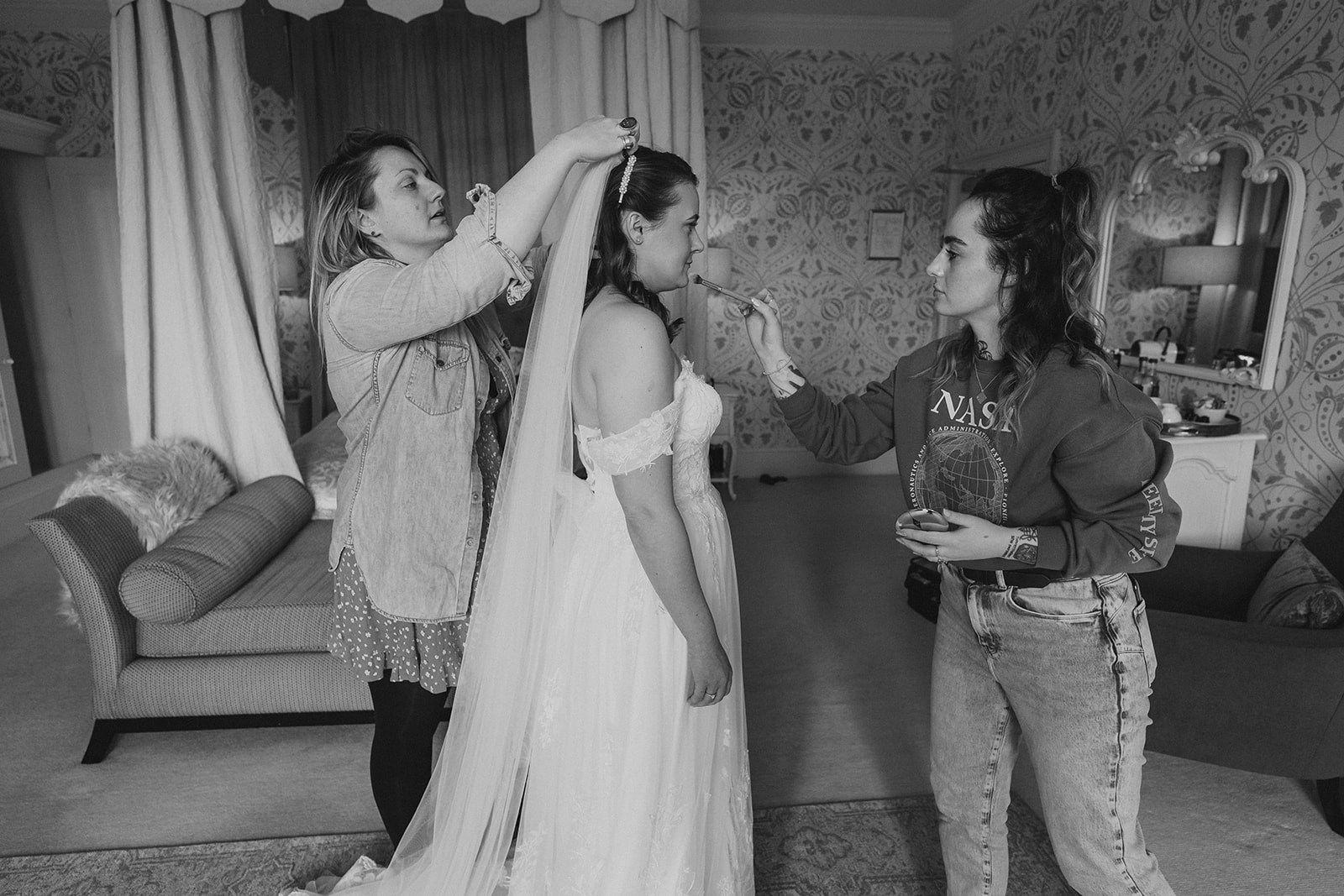 The bride, having the final make up touches after putting on her wedding dress