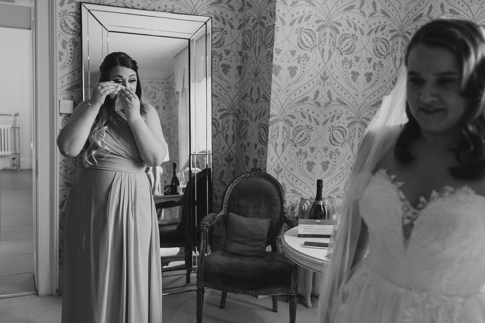 A bridesmaid getting emotional, seeing the bride in her wedding dress