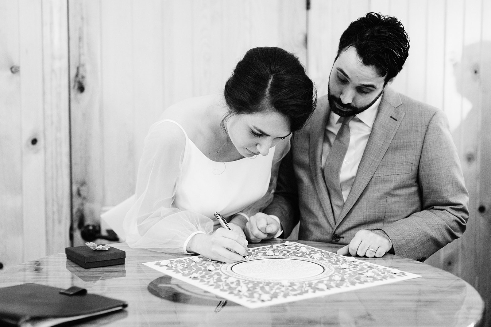 Bride and groom sign the ketubah