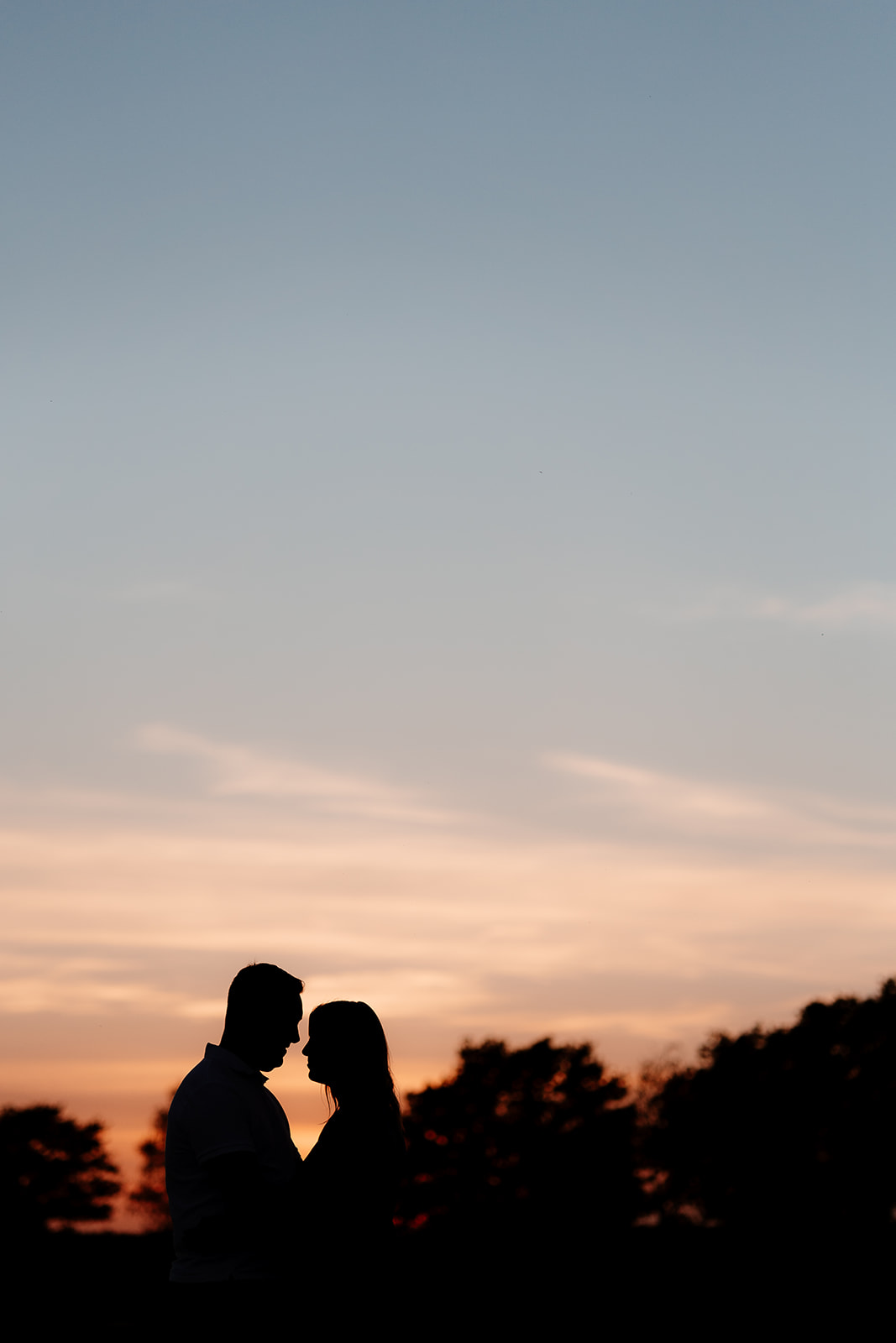Sunset silhouette photograph of a newly engaged couple on a photoshoot in the New Forest. 