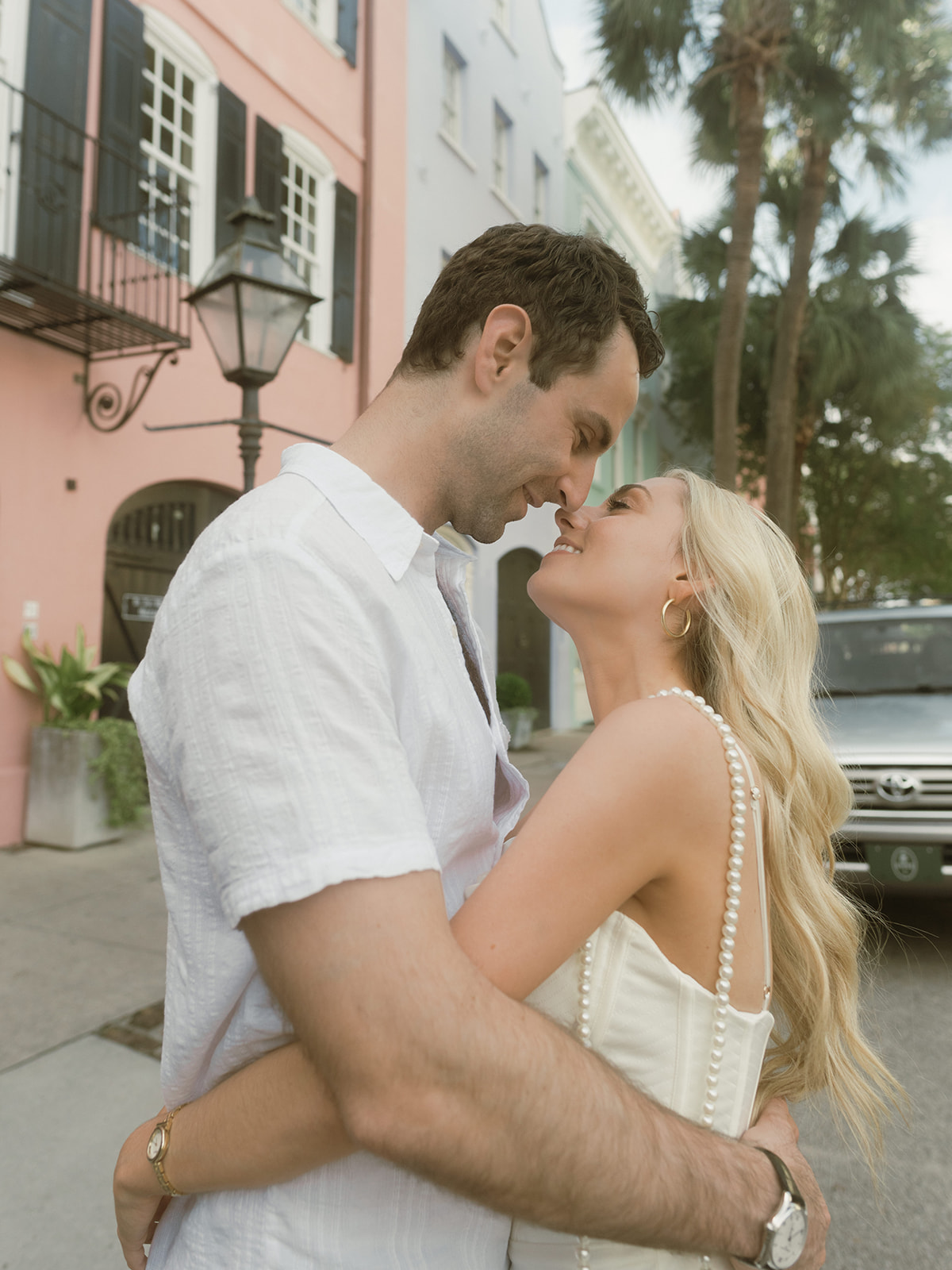Kissing on Rainbow Row in Charleston, SC for their editorial engagement session with Taylor English