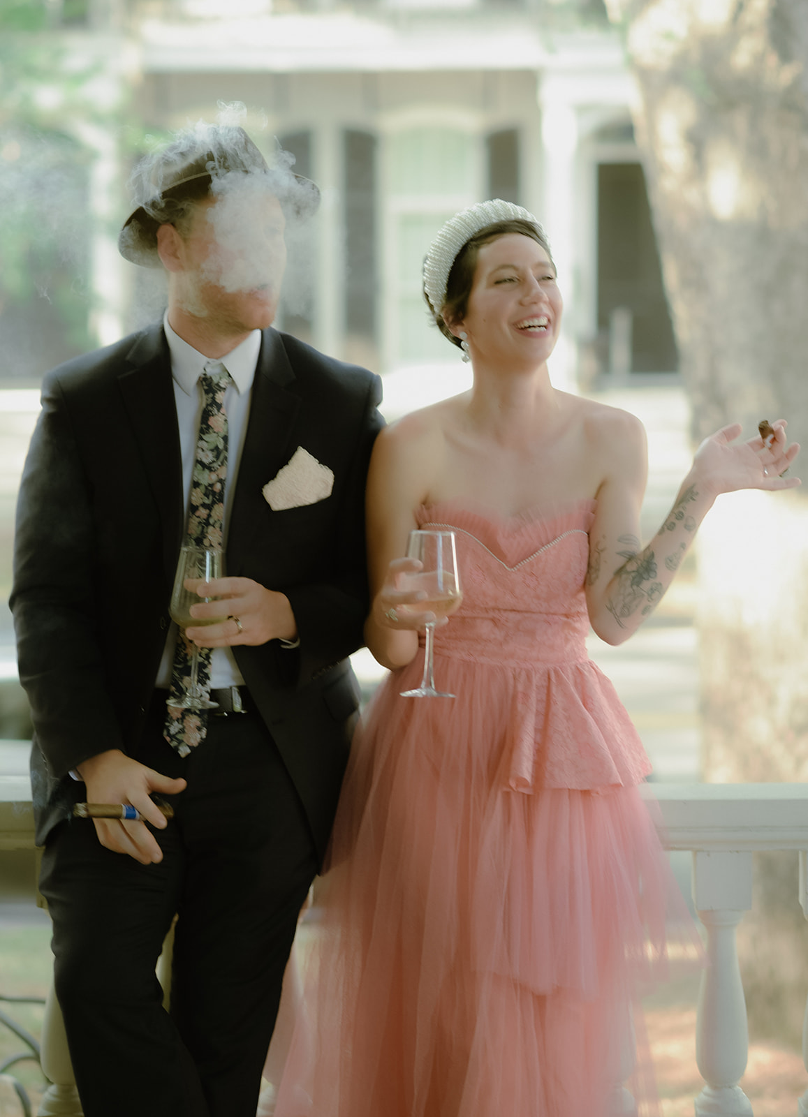 Celebrating with champagne and cigars on the porch of their bed and breakfast after their elopement