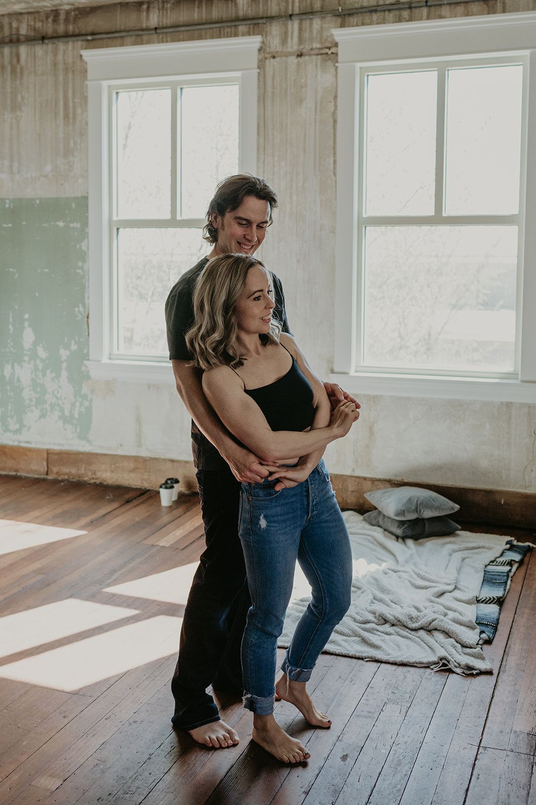 A couple cuddles in an intimate loft space engagement session in Vermilion Alberta.